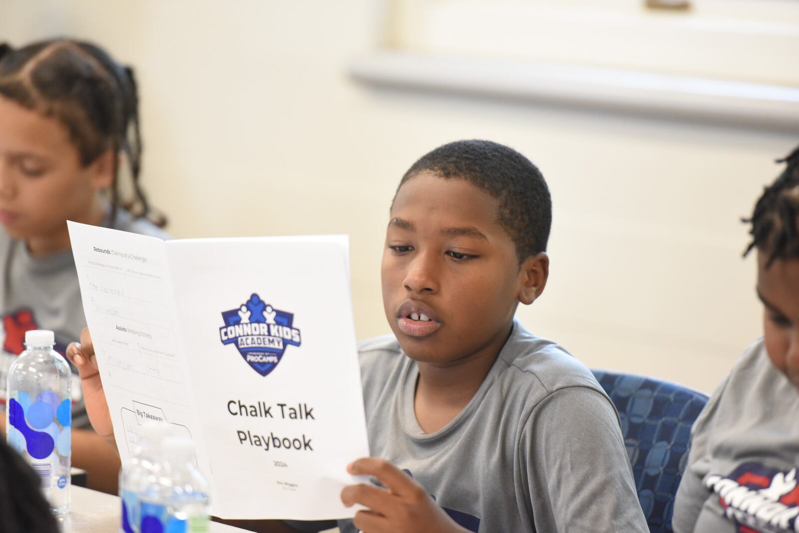 Upcoming sixth grader Eric Wiggins reading his Connor Kids Academy Chalk Talk Playbook during a classroom session this past week at the Frericks Center on the University of Dayton campus. CONTRIBUTED