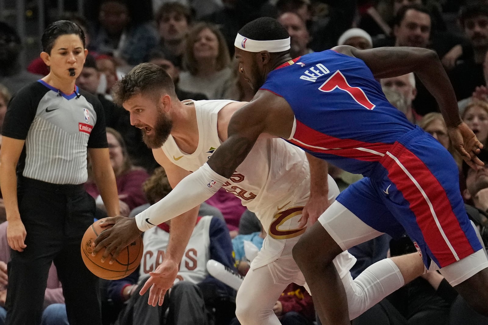 Cleveland Cavaliers forward Dean Wade, front left, steals the ball from Detroit Pistons forward Paul Reed (7) in the first half of an NBA basketball game, Friday, Oct. 25, 2024, in Cleveland. (AP Photo/Sue Ogrocki)