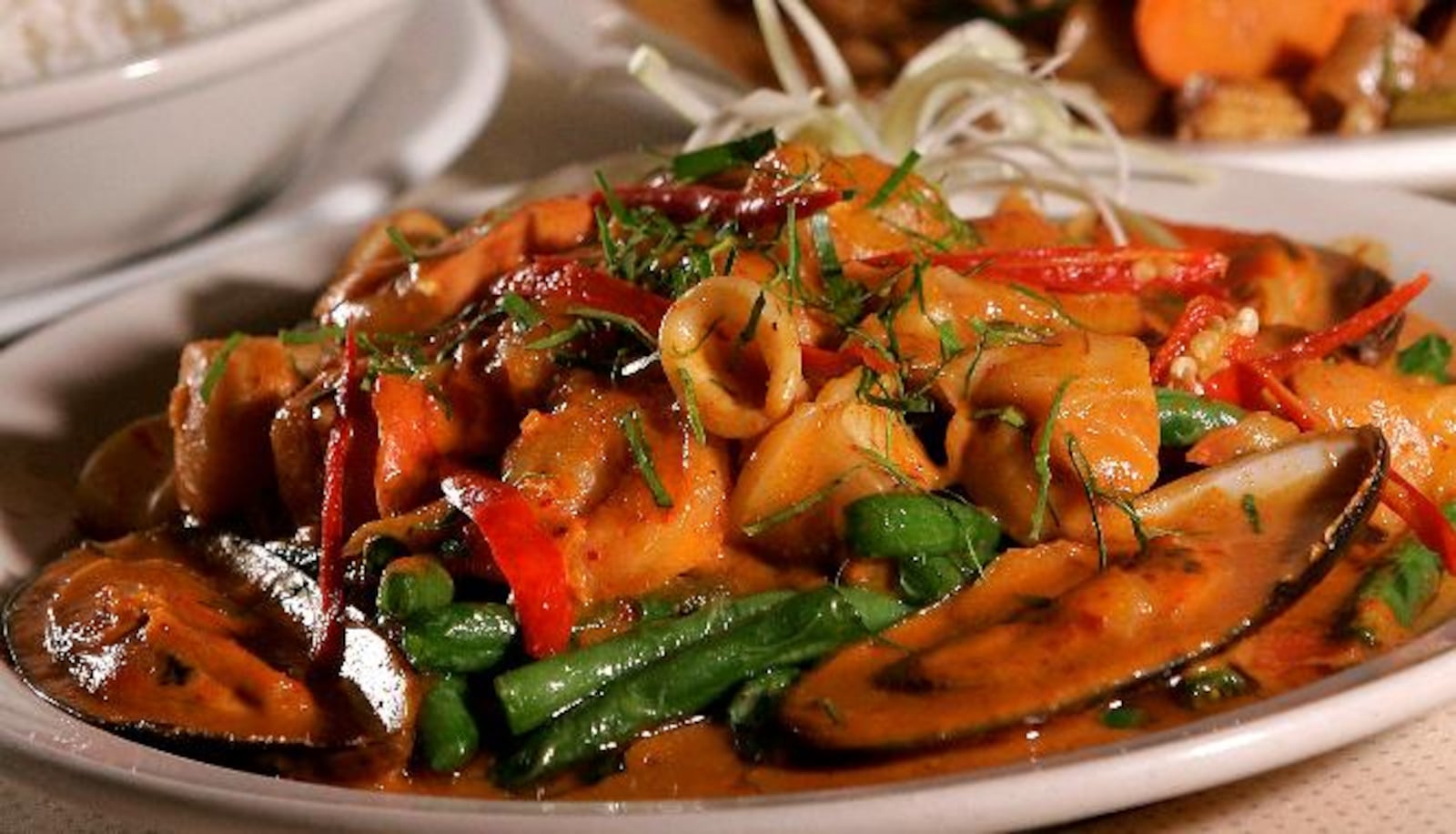 Panang curry with seafood (foreground) and spicy fried noodles with vegetables (back) at Thai 9 located in Dayton's Oregon District. Staff photo by Lisa Powell