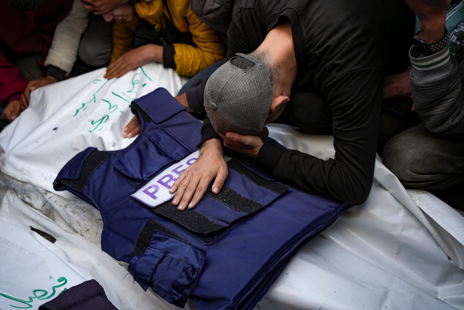 A relative mourns over the body of one of the five Palestinian journalists who were killed by an Israeli airstrike in Gaza City at the Al-Aqsa Hospital in Deir al-Balah, Thursday, Dec. 26, 2024. (AP Photo/Abdel Kareem Hana)