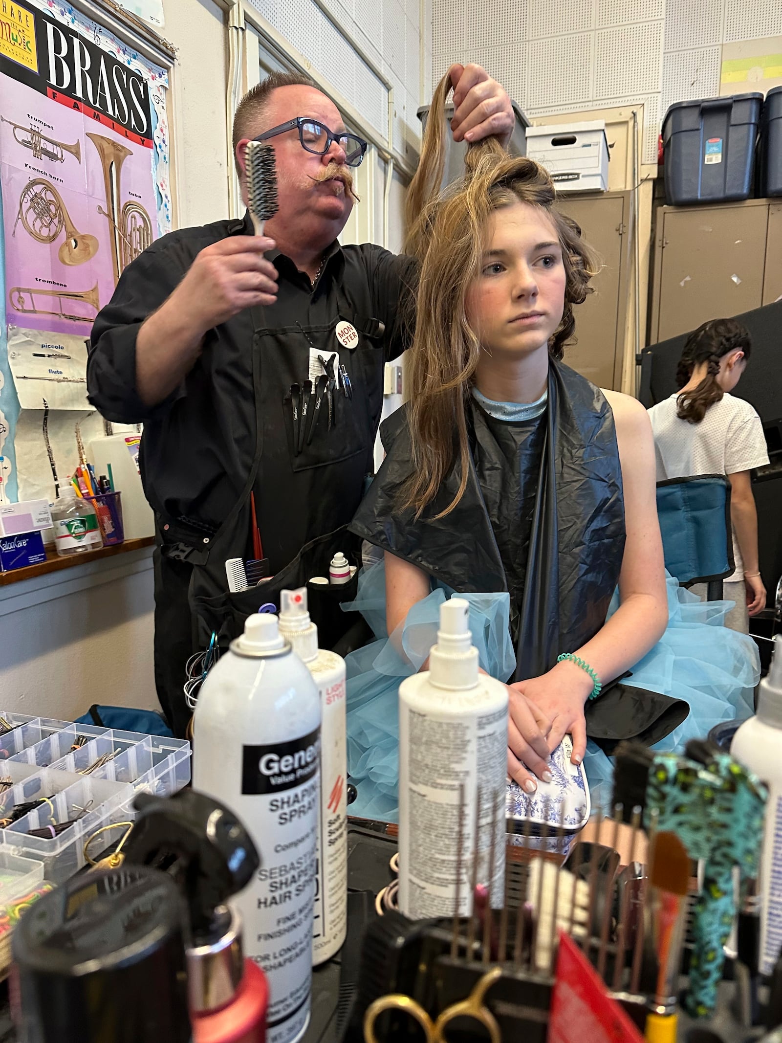 Hollywood hair stylist Randy Sayer, left, styles hair for Ella Warmer, 14, on opening night of the musical Crazy for You as the group makes a triumphant return to the stage after losing their theater in the Palisades fire, Los Angeles, California, Feb. 28, 2025. (AP Photo/Jocelyn Gecker)