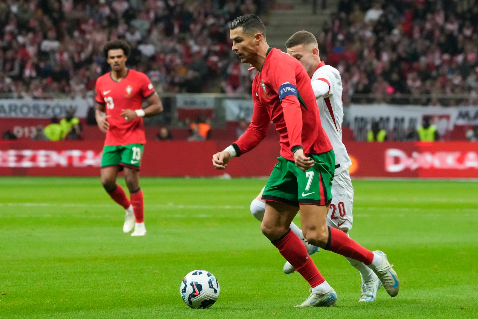 Portugal's Cristiano Ronaldo, front, and Poland's Sebastian Szymanski compete for the ball during the UEFA Nations League soccer match between Poland and Portugal at Narodowy stadium in Warsaw, Poland, Saturday, Oct. 12, 2024. (AP Photo/Czarek Sokolowski)