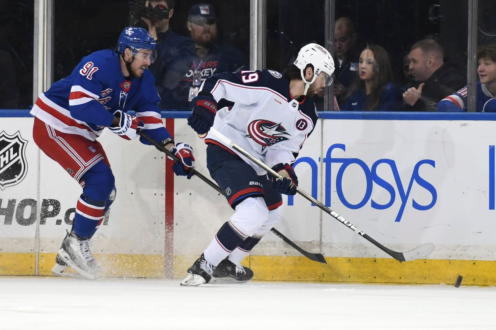 New York Rangers' Reilly Smith, left, and Columbus Blue Jackets' Adam Fantilli, right, chase after the puck during the first period of an NHL hockey game Saturday, Jan. 18, 2025, in New York. (AP Photo/Pamela Smith)