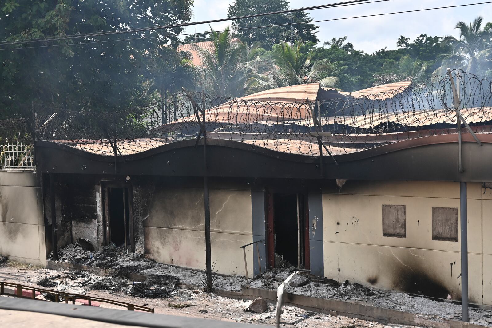 Smoke rises from the French embassy in Kinshasa, Democratic Republic of the Congo Tuesday, Jan. 28, 2025, after it was attacked when people protested against the Rwanda-backed M23 rebels' advances into eastern Congos capital Goma. (AP Photo/Samy Ntumba Shambuyi)