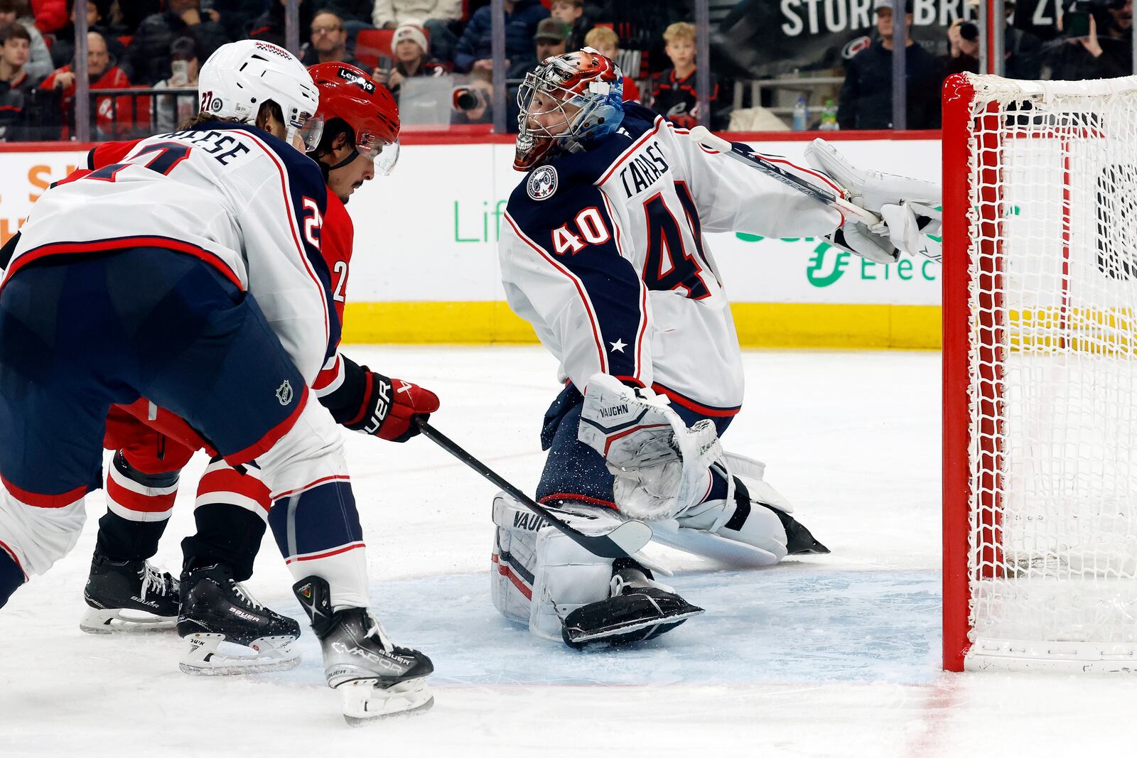 Carolina Hurricanes' Seth Jarvis, center, shoots the puck between Columbus Blue Jackets goaltender Daniil Tarasov (40) and Zachary Aston-Reese (27) for a goal during the second period of an NHL hockey game in Raleigh, N.C., Thursday, Jan. 23, 2025. (AP Photo/Karl DeBlaker)