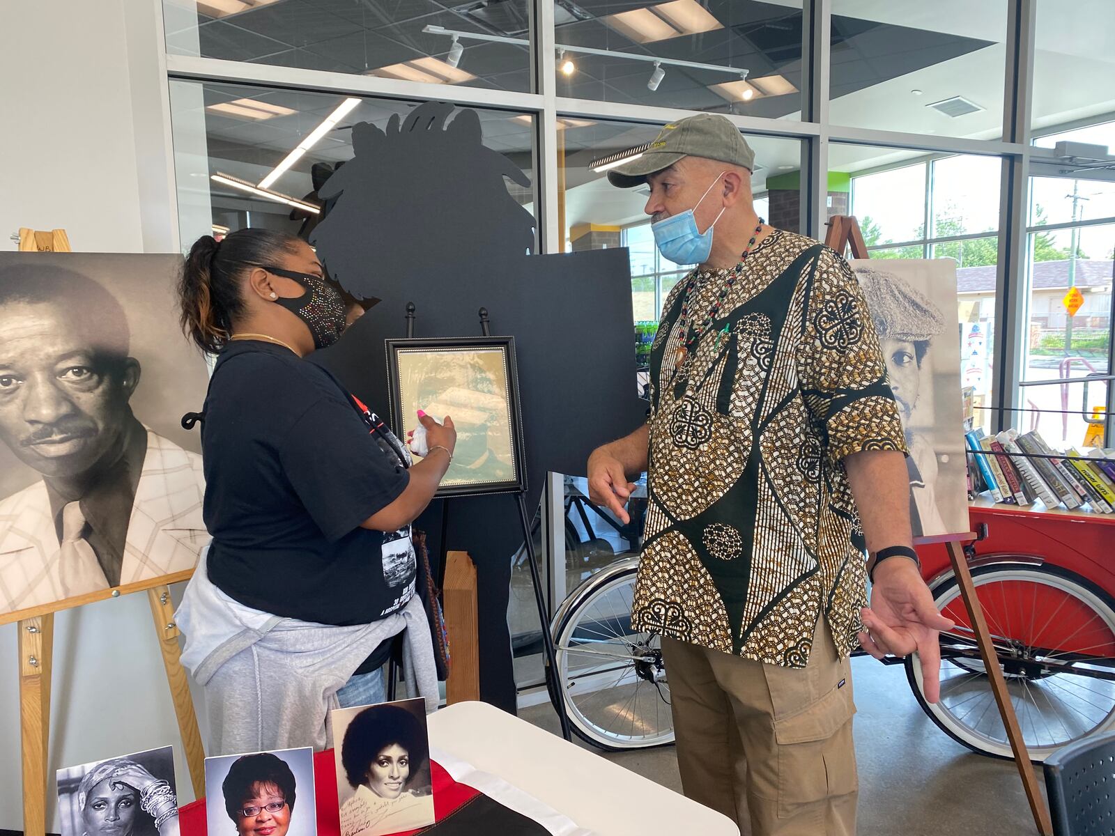 Kenya Baker, left, speaks with Kueko Larry Crowe, right, about members of the Black Dayton community on Saturday at Gem City Market. Eileen McClory / Staff