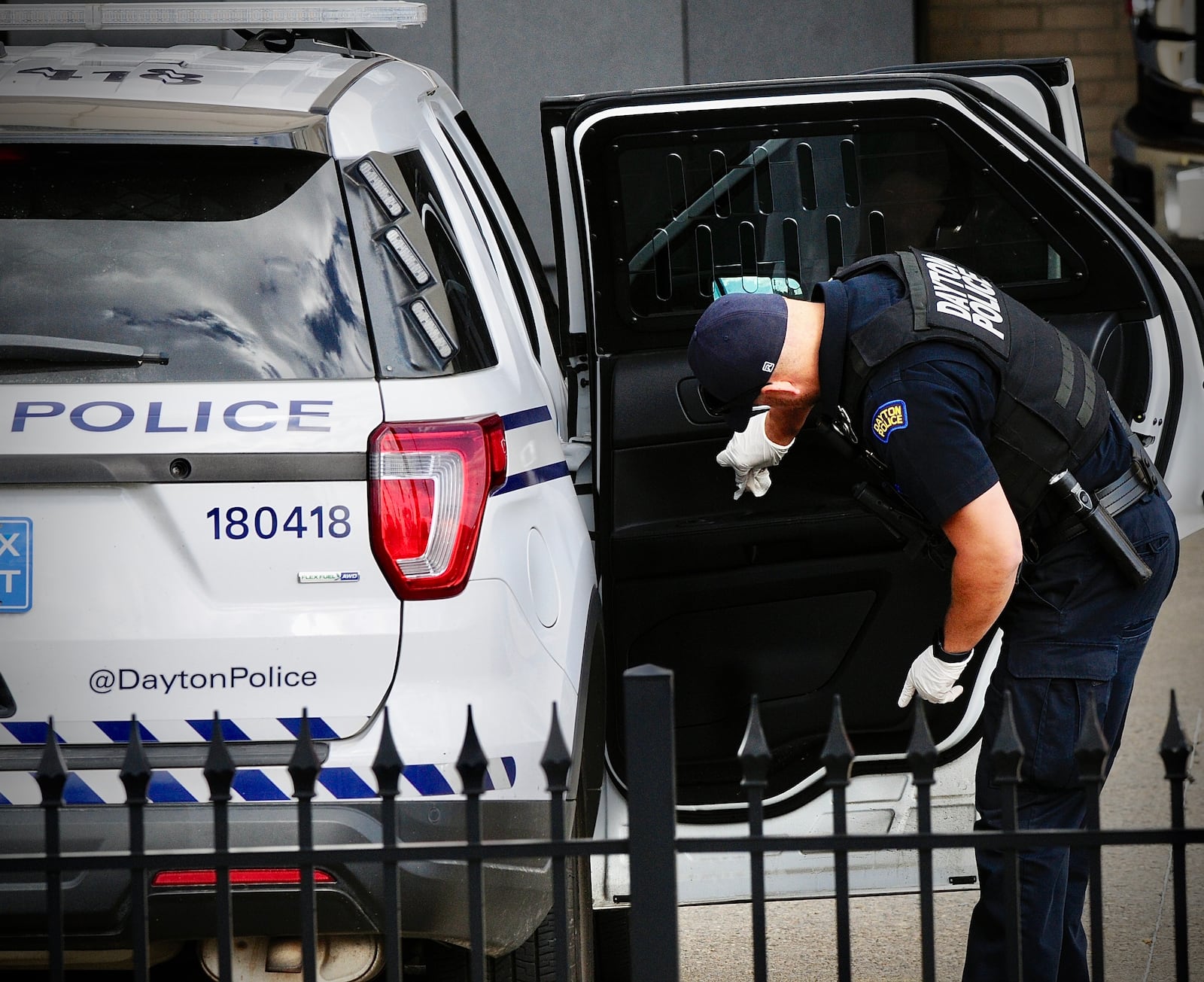 Dayton police forensic services examine the Dayton police cruiser outside Miami Valley Hospital Thursday, Oct. 13, 2022, that brought a Dayton officer stabbed during a call on Bancroft Avenue to the hospital. MARSHALL GORBY \STAFF