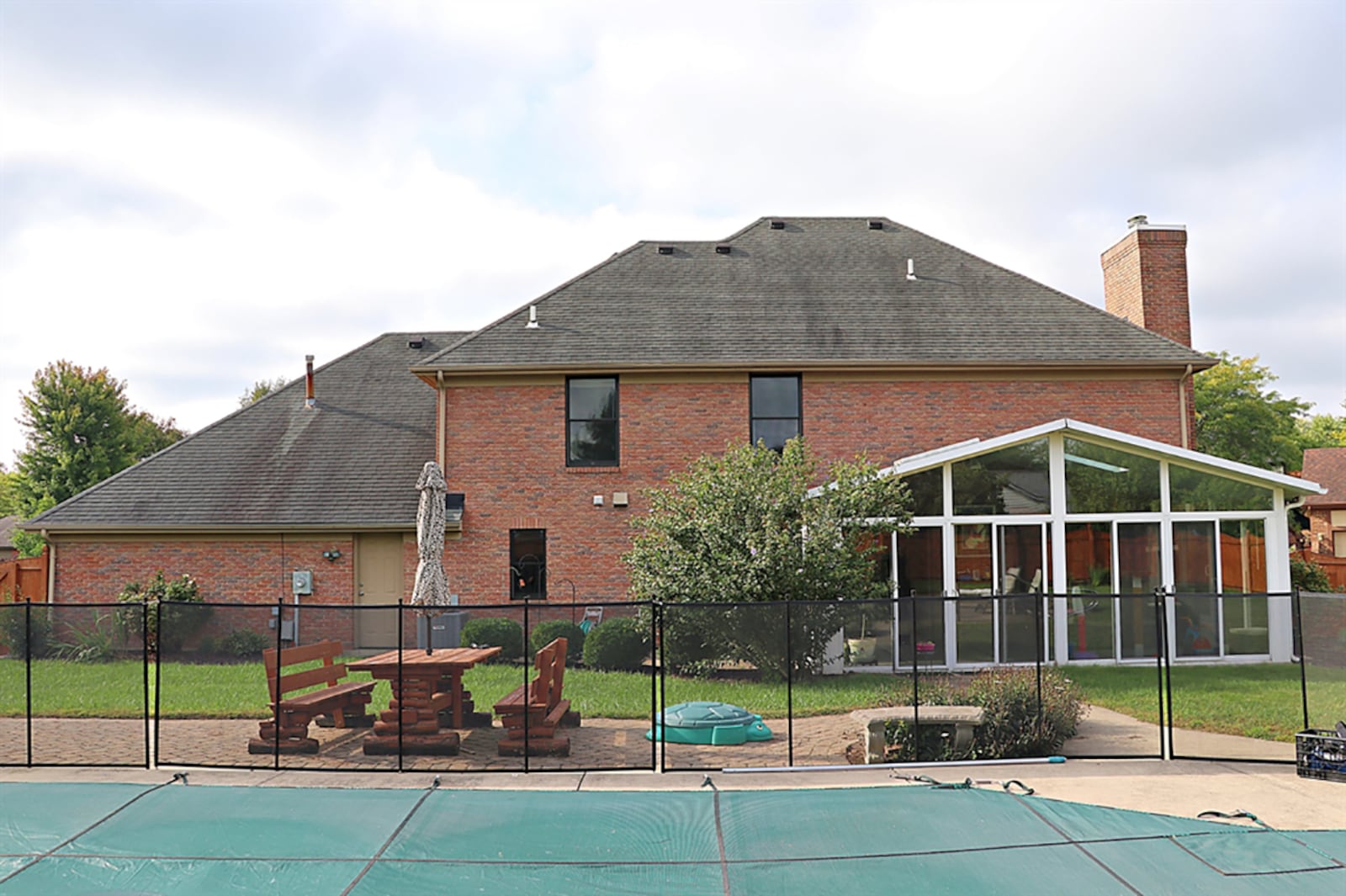 Sliding patio doors open into the solarium which has a cathedral ceiling, skylights, ceramic-tile flooring and walls of windows that provide panoramic views of the backyard pool deck. CONTRIBUTED PHOTO BY KATHY TYLER