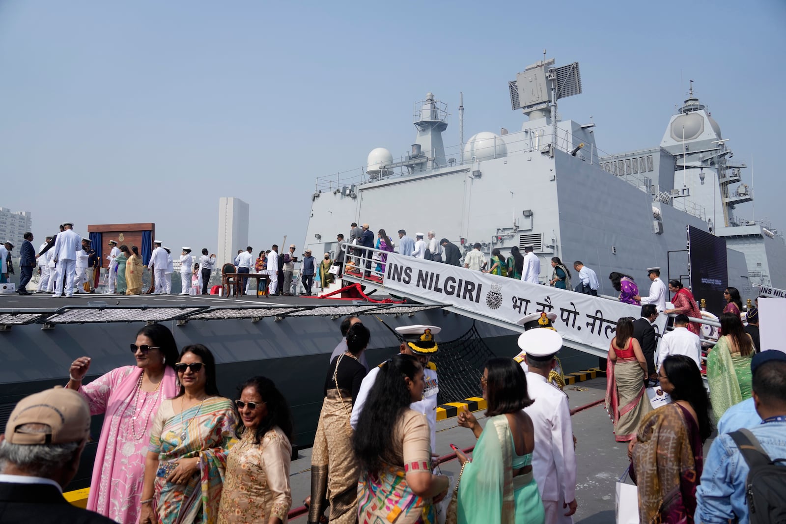 Indian naval officers walk with their family members after the commissioning of INS Nilgiri at a naval dockyard in Mumbai, India, Wednesday, Jan. 15, 2025. (AP Photo/Rafiq Maqbool)