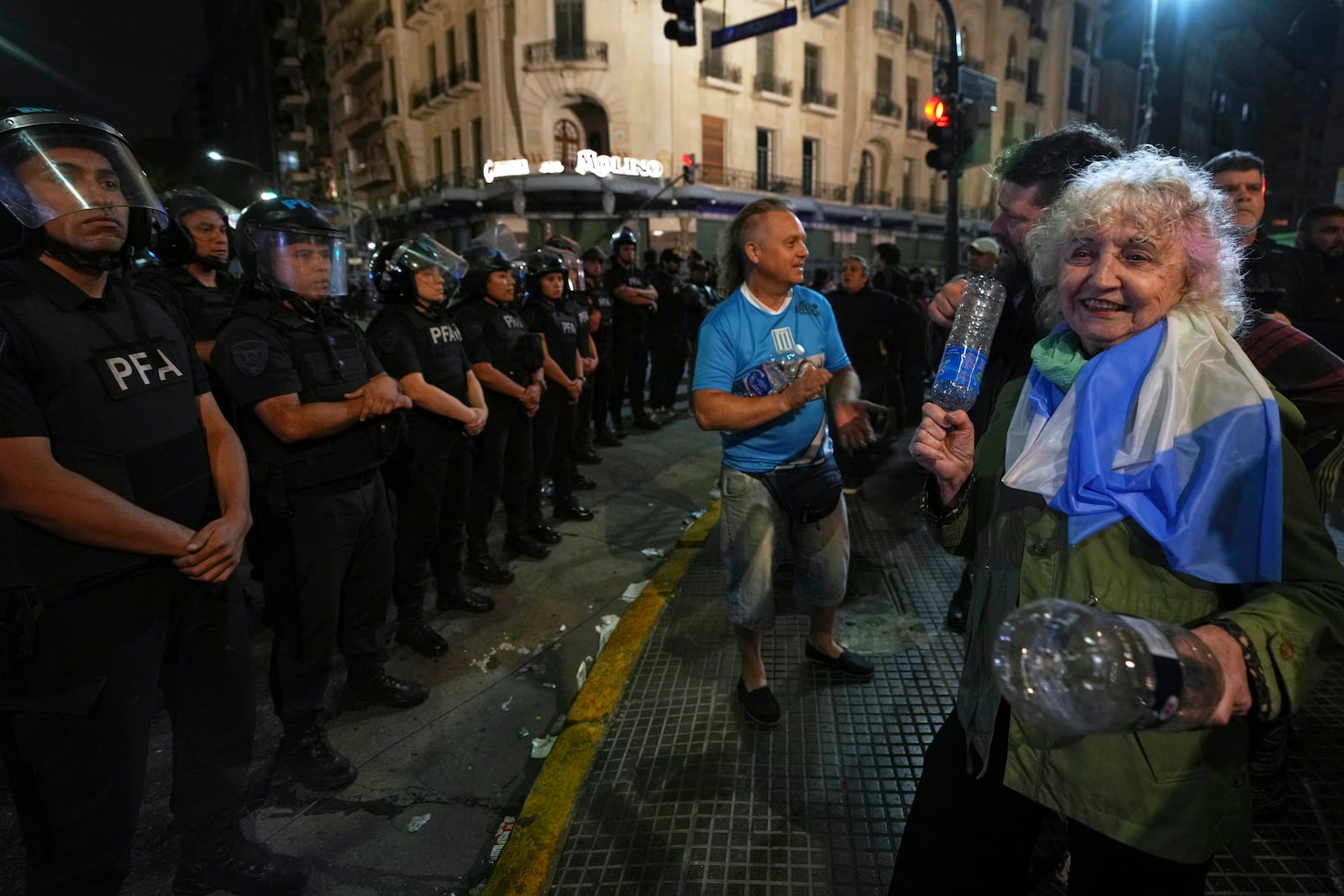 A woman bangs plastic bottles together during a protest for higher pensions and against austerity measures implemented by Javier Milei's government in Buenos Aires, Argentina, Wednesday, March 12, 2025. (AP Photo/Natacha Pisarenko)