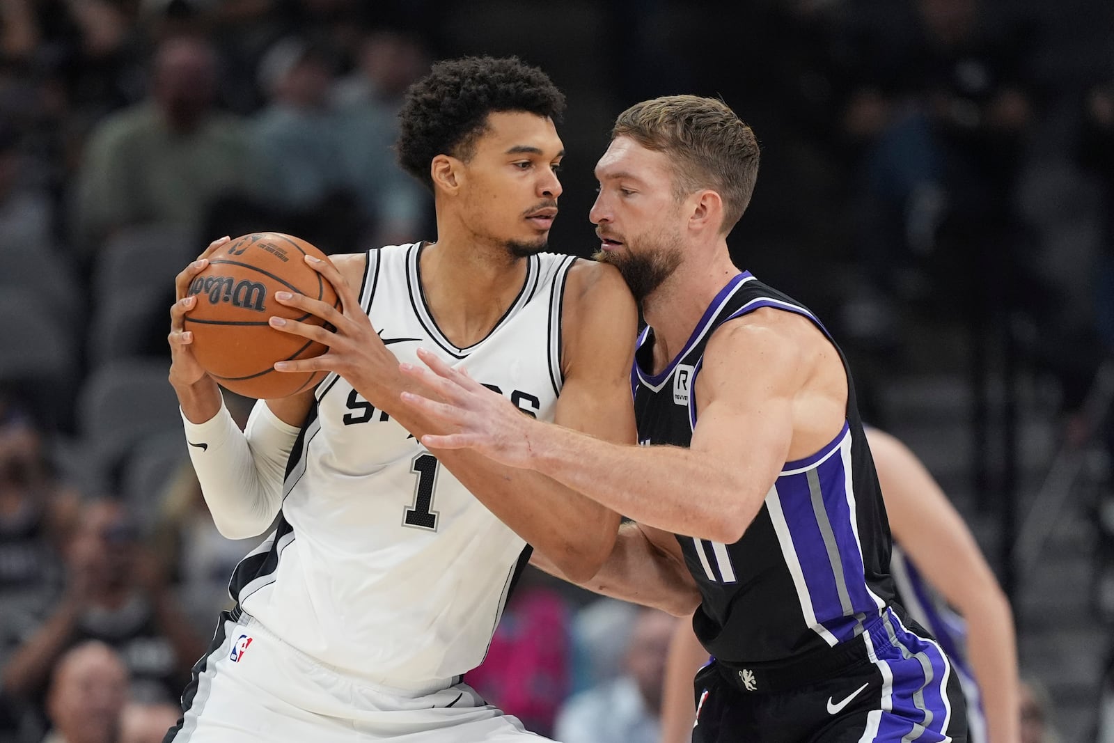 San Antonio Spurs center Victor Wembanyama (1) is defended by Sacramento Kings forward Domantas Sabonis during the first half of an NBA basketball game in San Antonio, Monday, Nov. 11, 2024. (AP Photo/Eric Gay)