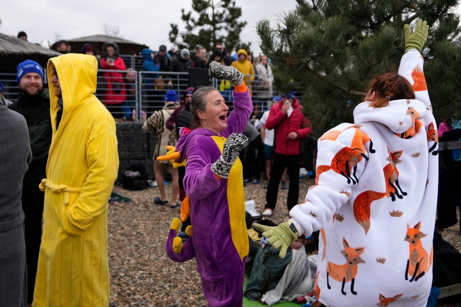 Some of 2461 polar swimmers warm up before going to the water to set a world record for the largest polar bear dip at a lake in Most, Czech Republic, Saturday, March 1, 2025. (AP Photo/Petr David Josek)