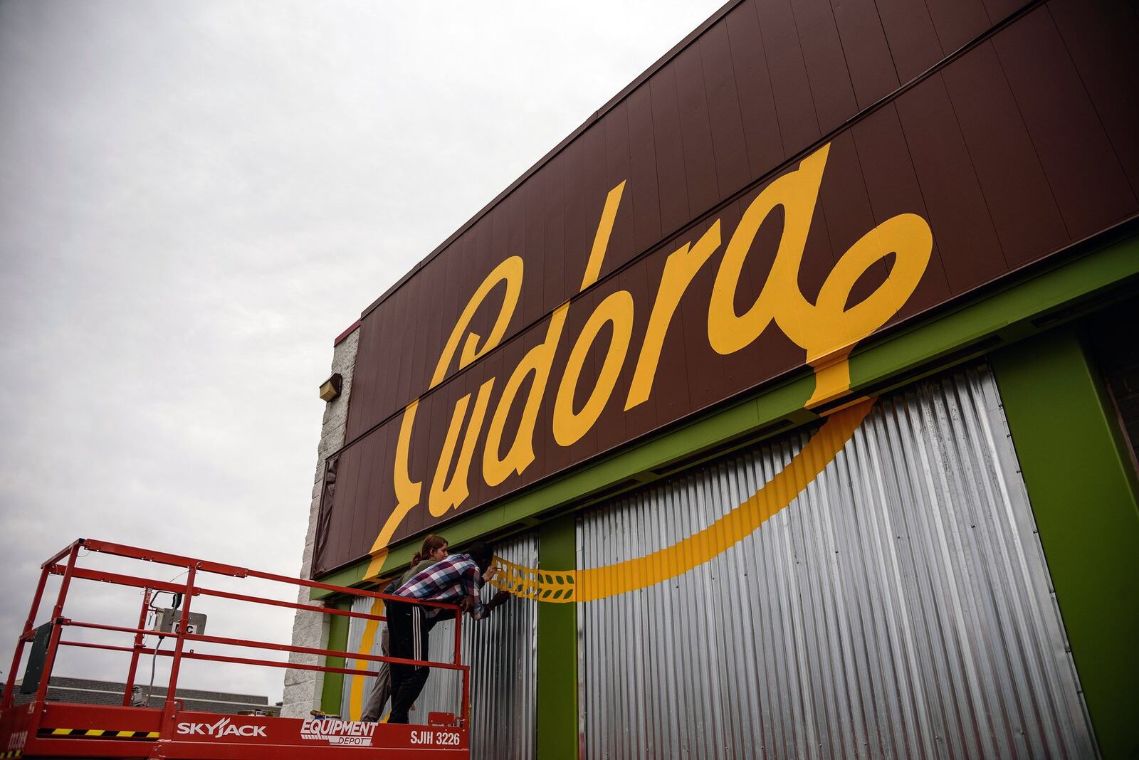 Artists finish painting the Eudora logo on the side of the new location — a building that formerly housed an auto mechanic shop, on Wilmington Pike. The new location opens on Friday, Jan. 11. CONTRIBUTED/TOM GILLIAM