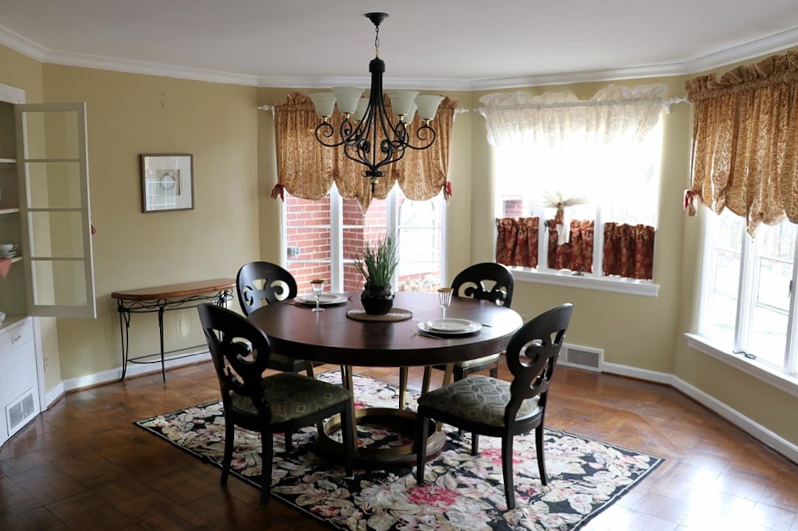 Three walls of windows fill the dining room with natural light. A built-in china hutch has a four glass-panel door and linen drawer. CONTRIBUTED BY KATHY TYLER