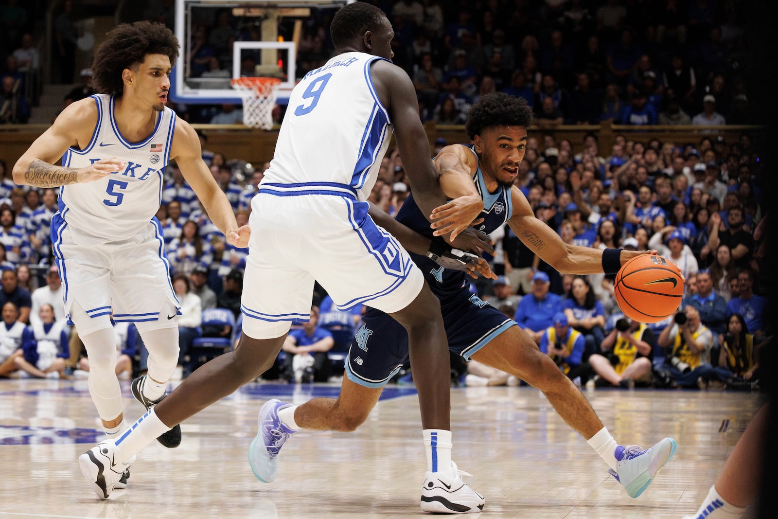 Maine's Caleb Crawford, right, handles the ball as Duke's Khaman Malauch (9) and Tyrese Proctor (5) defend during the first half of an NCAA college basketball game in Durham, N.C., Monday, Nov. 4, 2024. (AP Photo/Ben McKeown)