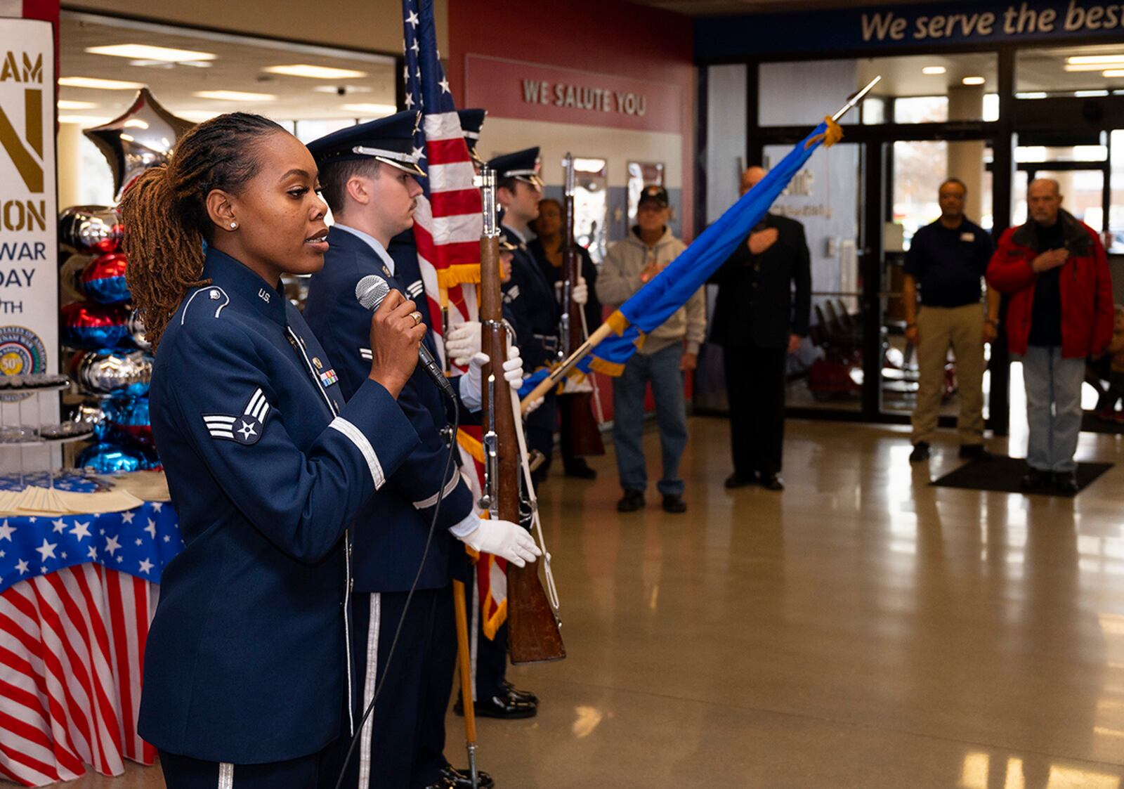 Senior Airman MeLan Smartt, Air Force Band of Flight soloist, sings the national anthem as the Wright-Patterson Air Force Base Honor Guard presents colors during a pinning ceremony at the Main Exchange on March 29 in observance of National Vietnam War Veterans Day. The Army & Air Force Exchange Service provided free lapel pins in honor of veterans who served between Nov. 1, 1955, and May 15, 1975. U.S. AIR FORCE PHOTO/R.J. ORIEZ