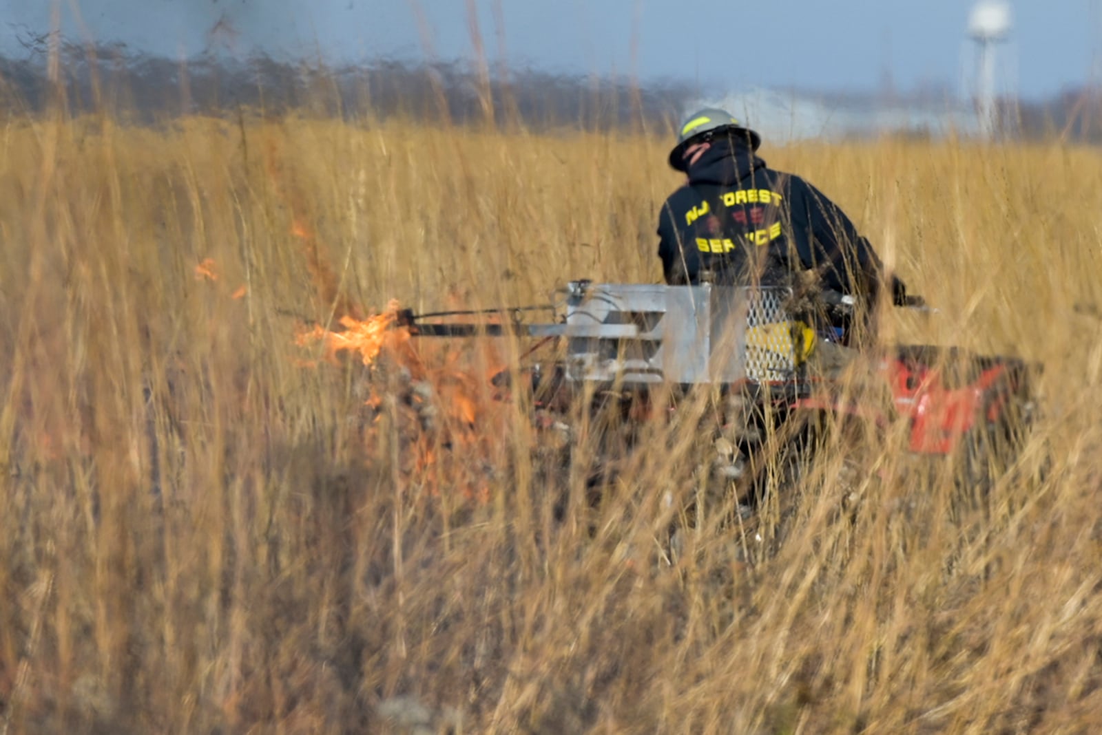 A firefighter uses a torch to set fire to parts of Huffman Prairie as part of the annual prescribed burn. U.S. AIR FORCE PHOTO/WESLEY FARNSWORTH