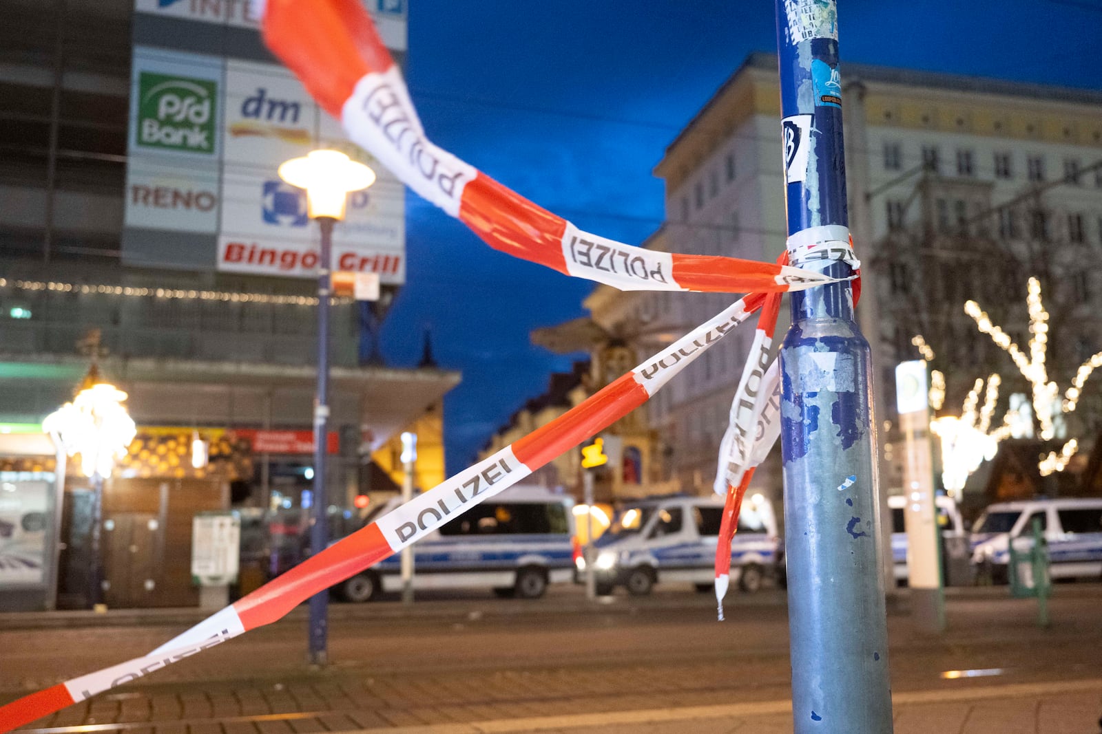 A barrier tape and police vehicles are seen in front of the entrance to the Christmas market in Magdeburg after a driver plowed into a busy Christmas market in Magdeburg, Germany, Saturday, Dec. 21, 2024. (Sebastian Kahnert/dpa via AP)