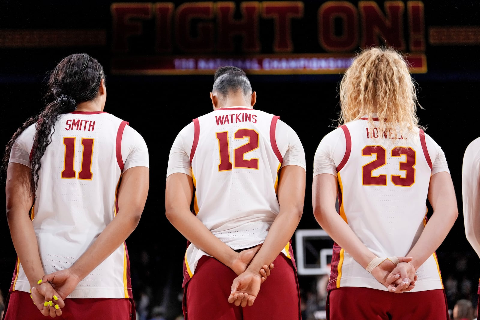 Southern California's Kennedy Smith, left, JuJu Watkins, center, and Avery Howell listen to the national anthem prior to an NCAA college basketball game against Michigan, Sunday, Dec. 29, 2024, in Los Angeles. (AP Photo/Mark J. Terrill)