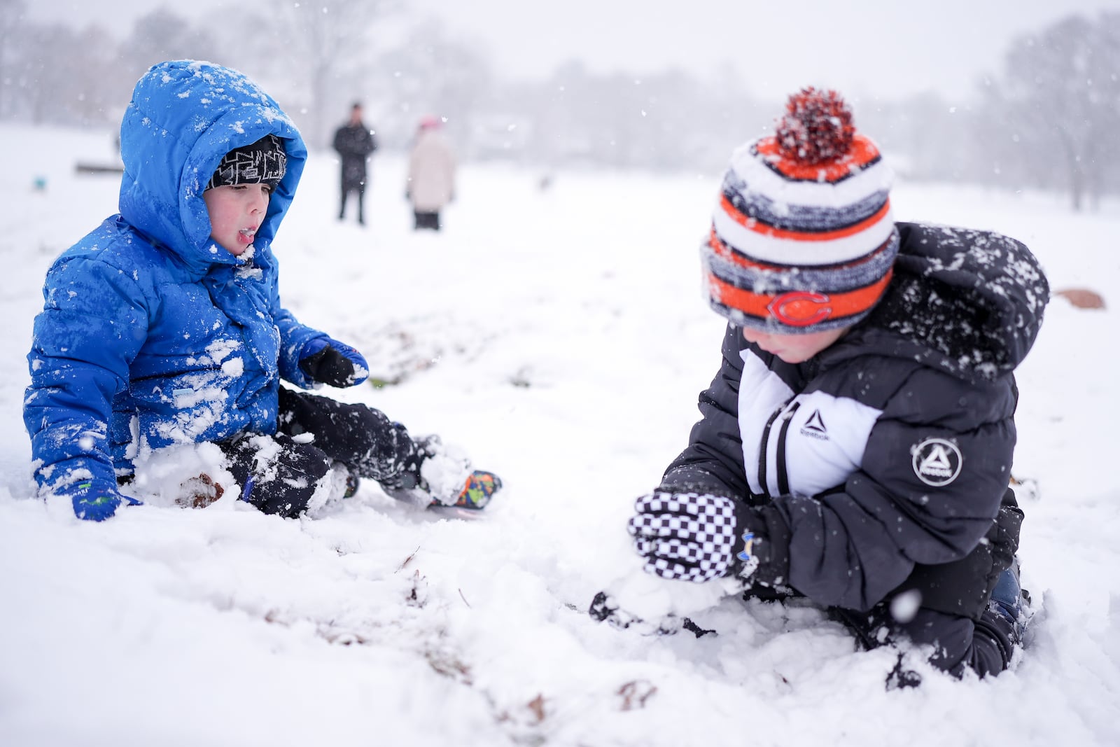 Maddox Chappell, 4, left, and his brother River Chappell, 6, right, play in the snow Friday, Jan. 10, 2025, in Nashville, Tenn. (AP Photo/George Walker IV)