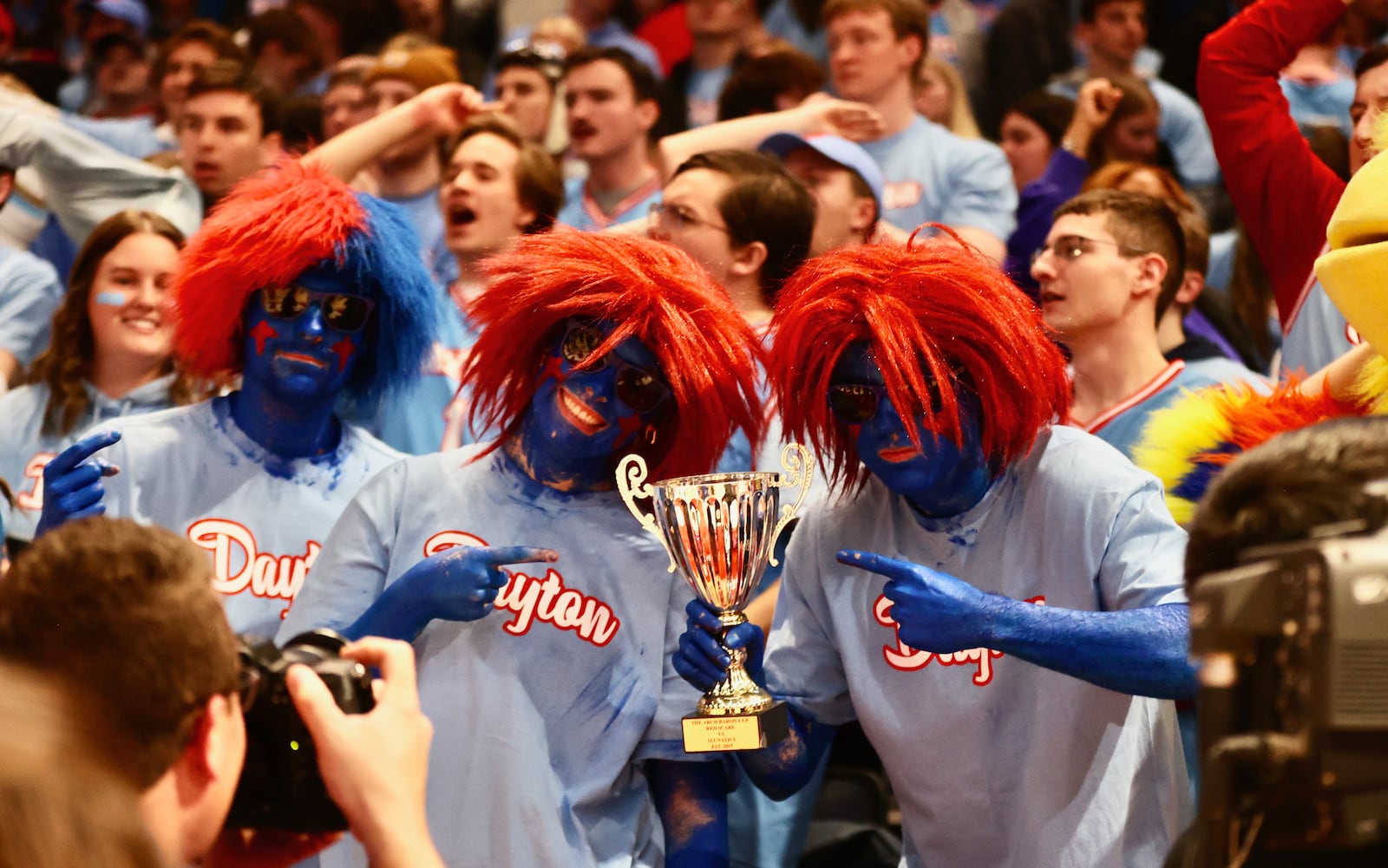 Dayton fans in the Red Scare student section hold up the Arch Baron Cup after a victory against Saint Louis on Tuesday, Jan. 16, 2024, at UD Arena. David Jablonski/Staff