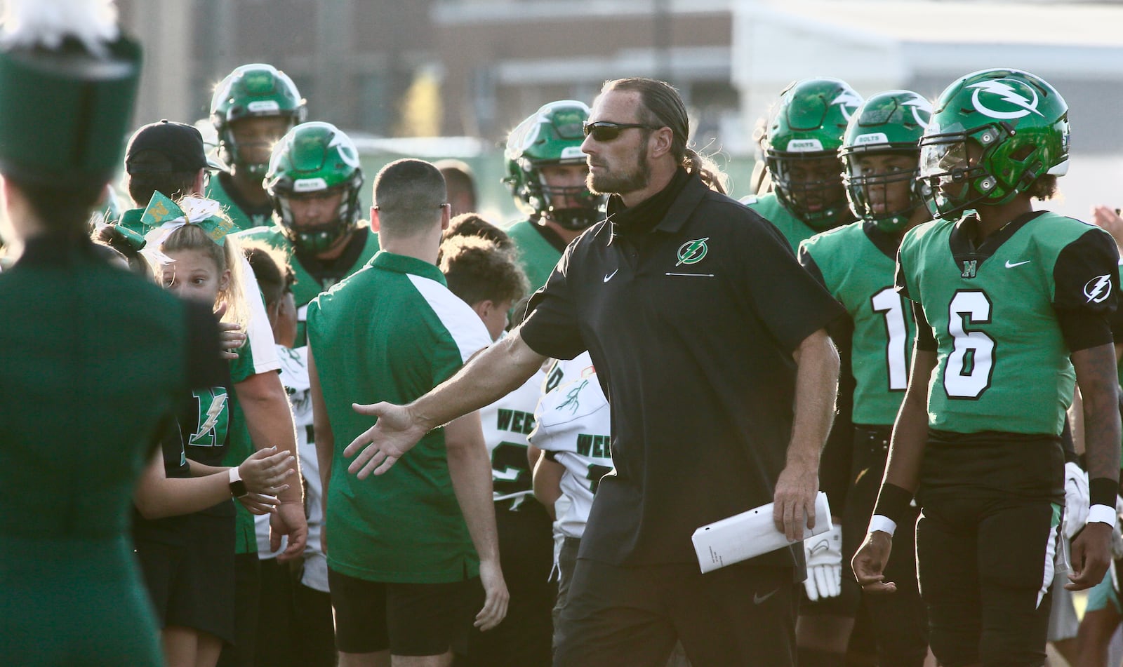 Northmont's Tony Broering slaps hands with kids before a game against Fairmont on Friday, Sept. 9, 2022, at Premier Health Stadium in Clayton. David Jablonski/Staff