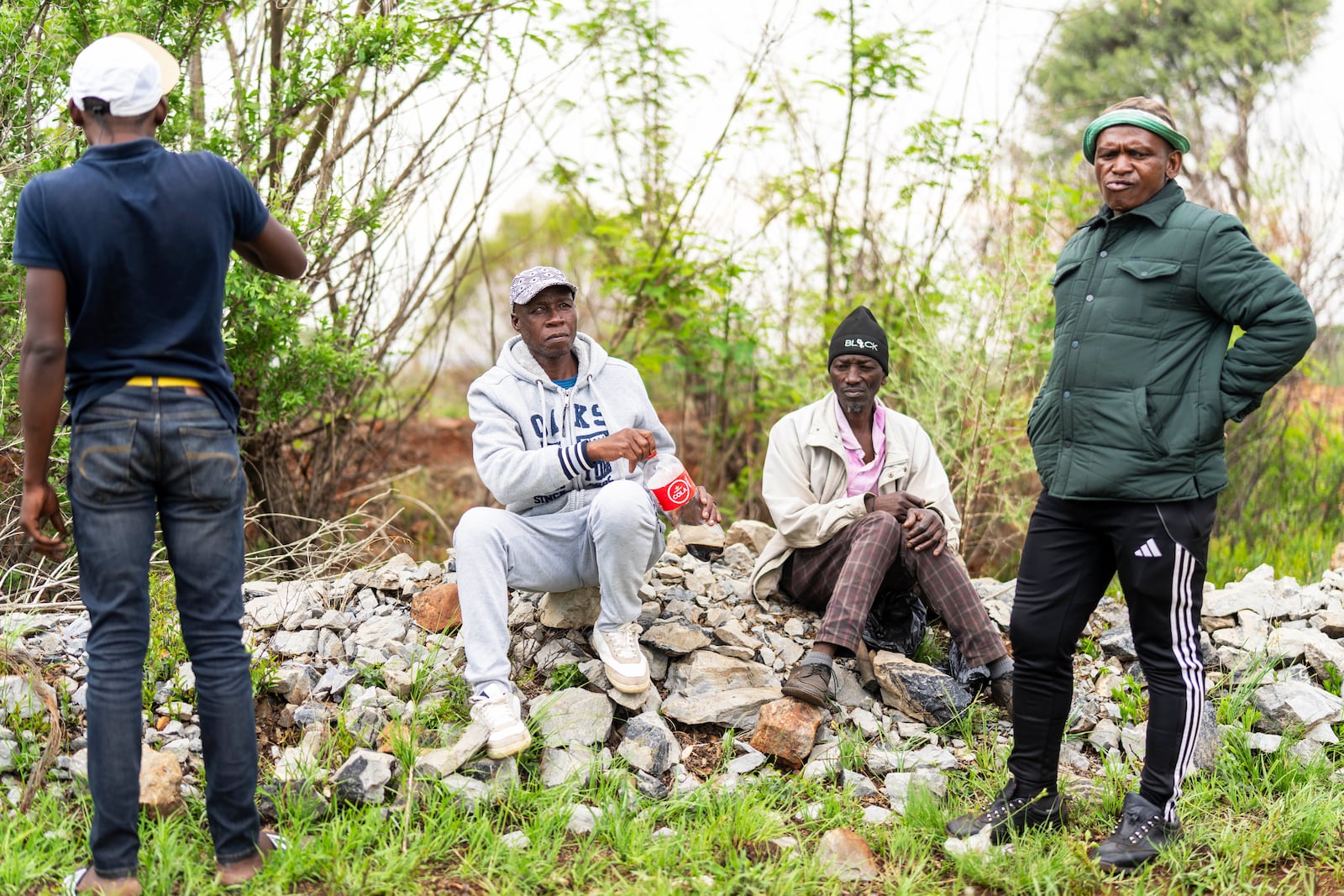 Relatives of miners and community members wait at a mine shaft where illegal miners are trapped in a disused mine in Stilfontein, South Africa, Thursday, Nov. 14, 2024. (AP Photo/Jerome Delay)