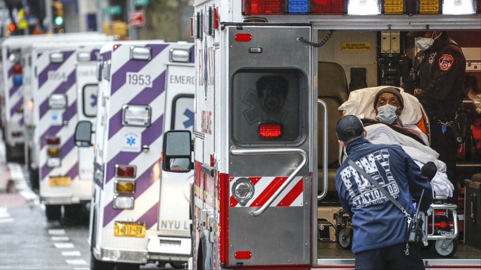 New York City fire medics unload a patient outside NYU Langone Medical Center April 13, 2020. The medics and patient wear personal protective equipment due to concerns about COVID-19, which has ravaged the city. (AP Photo/John Minchillo)