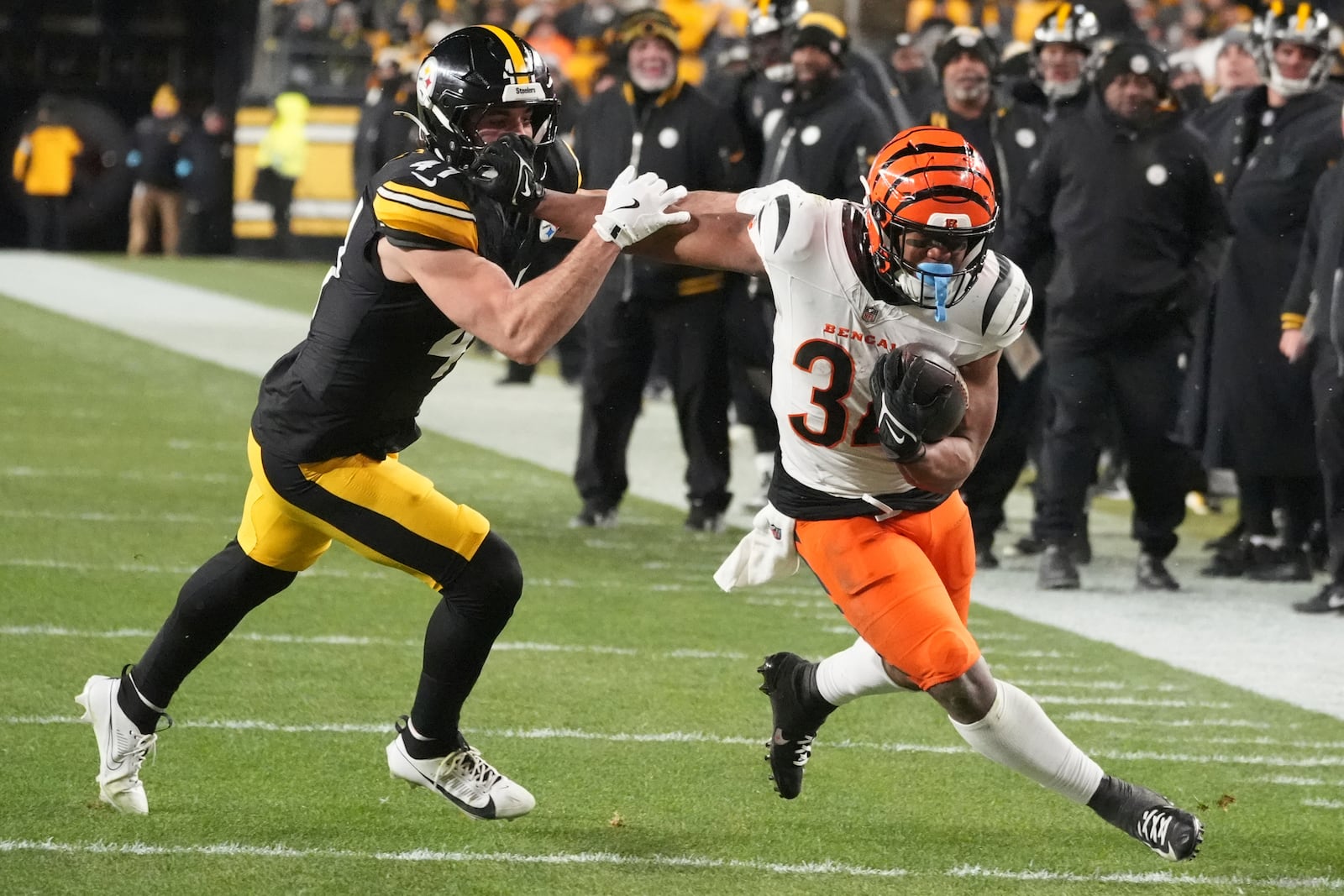 Cincinnati Bengals running back Khalil Herbert (34) runs with the ball as Pittsburgh Steelers linebacker Payton Wilson (41) defends during the second half of an NFL football game in Pittsburgh, Saturday, Jan. 4, 2025. (AP Photo/Gene J. Puskar)