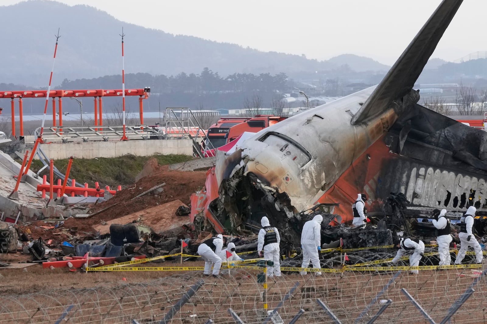 Rescue team members work at the site of a plane crash at Muan International Airport in Muan, South Korea, Tuesday, Dec. 31, 2024. (AP Photo/Ahn Young-joon)