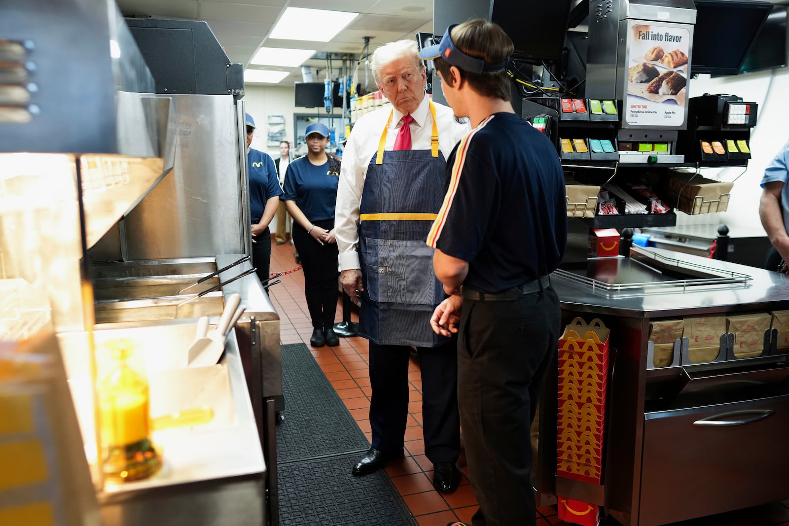 Republican presidential nominee former President Donald Trump, center, speaks with an employee behind the counter during a visit to McDonald's in Feasterville-Trevose, Pa., Sunday, Oct. 20, 2024. (Doug Mills/The New York Times via AP, Pool)