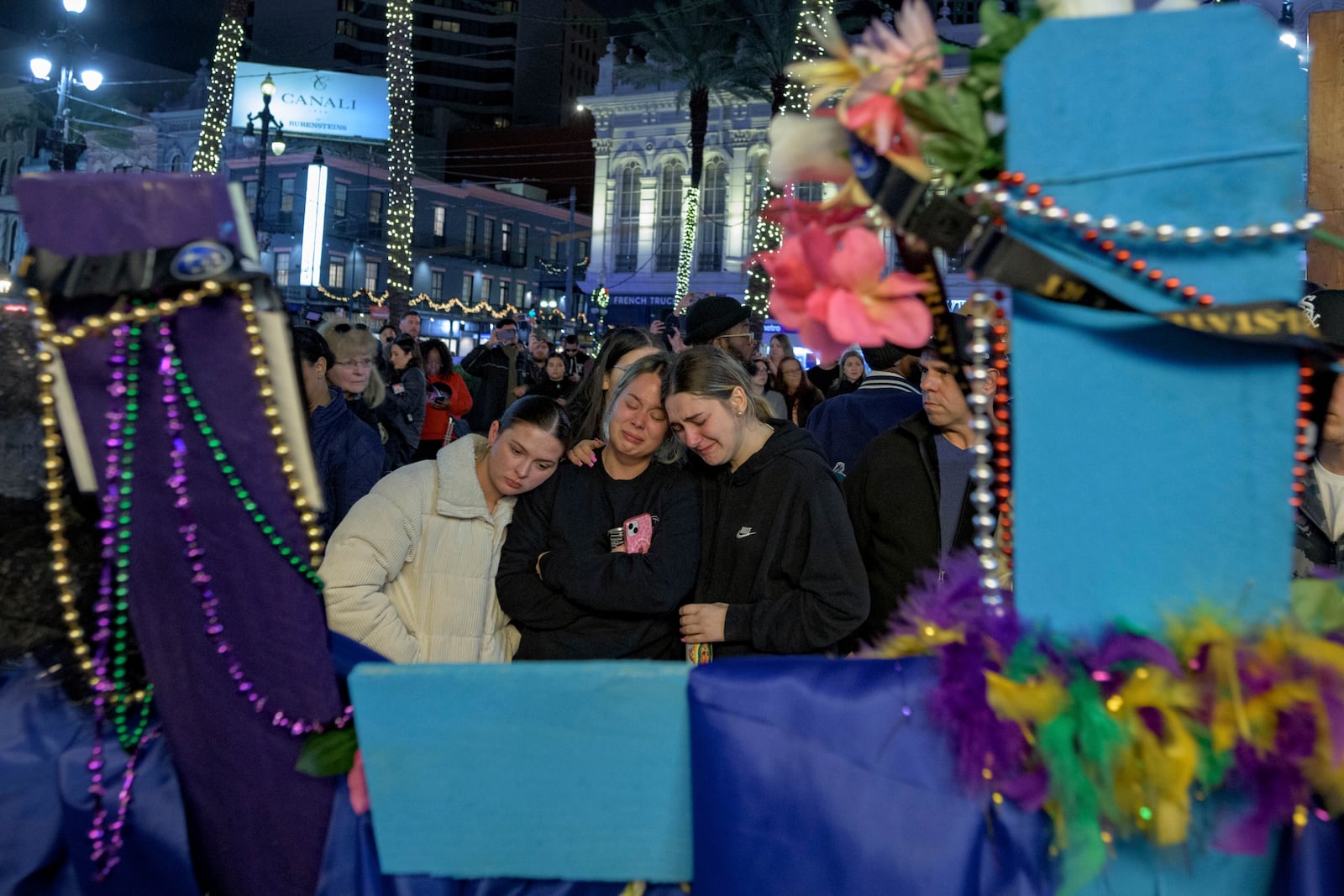 Mourners react next to crosses memorializing the victims of the New Year's Day deadly truck attack and shooting along Canal Street near the intersection of Bourbon Street in New Orleans, Saturday, Jan. 4, 2025. (AP Photo/Matthew Hinton)