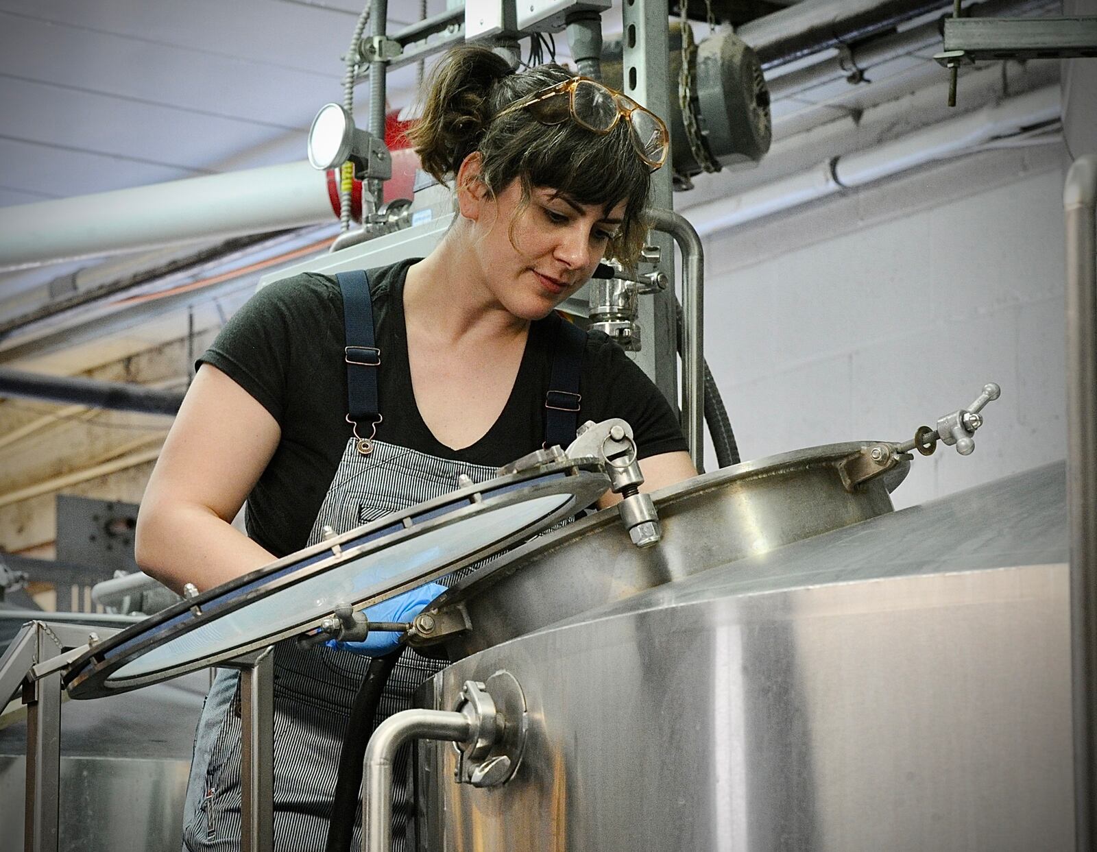 Yellow Springs Brewery employee Matalie Iseli-Smith cleans out a vat after brewing a batch of beer Thursday, April 20, 2023. MARSHALL GORBY \STAFF