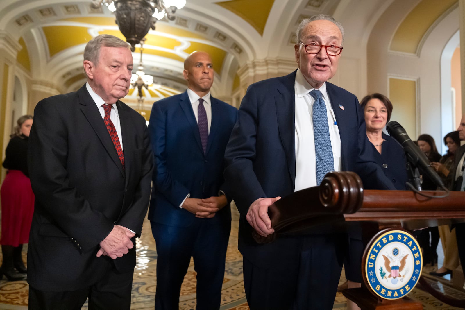 Senate Majority Leader Chuck Schumer of N.Y., speaks with reporters as, from left, Sen. Dick Durbin, D-Ill., Sen. Cory Booker, D-N.J., and Sen. Amy Klobuchar, D-Minn., listen on Capitol Hill, Tuesday, Dec. 3, 2024, in Washington. (AP Photo/Mark Schiefelbein)