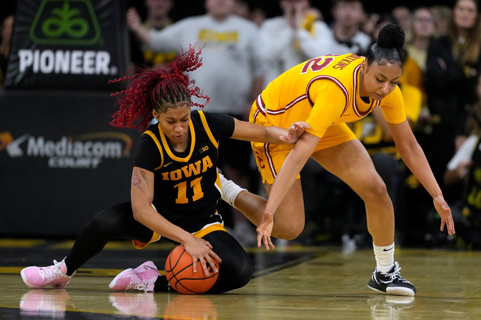 Iowa guard Aaliyah Guyton (11) steals the ball from Southern California guard JuJu Watkins, right, during the first half of an NCAA college basketball game, Sunday, Feb. 2, 2025, in Iowa City, Iowa. (AP Photo/Charlie Neibergall)