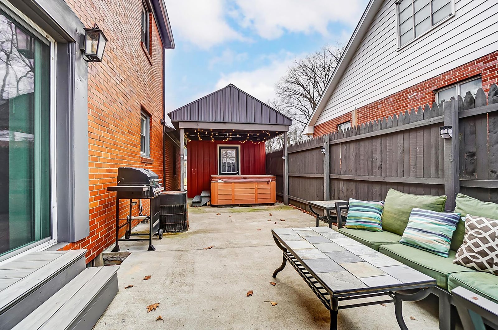 The rear of the home has a concrete patio with wood privacy fence around it. There is room for a covered hot tub at one end.