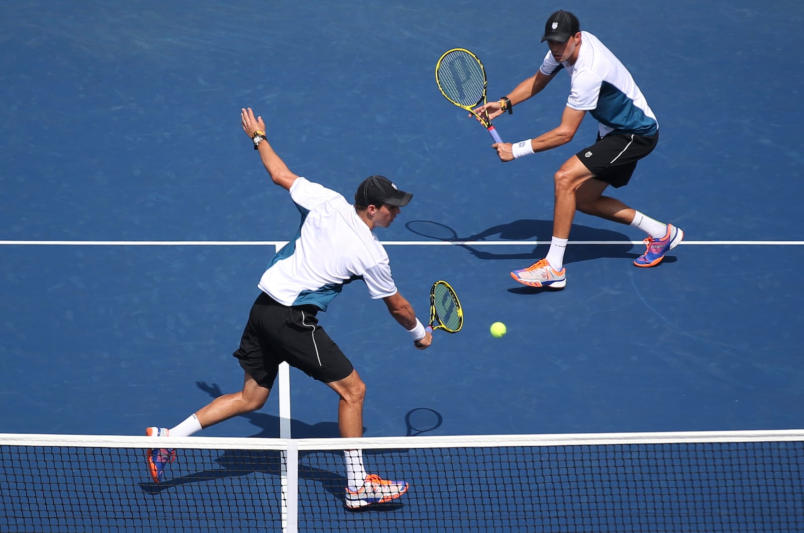 FILE - Mike Bryan, left, returns a shot as Bob Bryan looks on during a doubles match against Bradley Klahn, and Tim Smyczek, during the third round of the 2014 U.S. Open tennis tournament, Sept. 1, 2014, in New York. (AP Photo/John Minchillo, File)