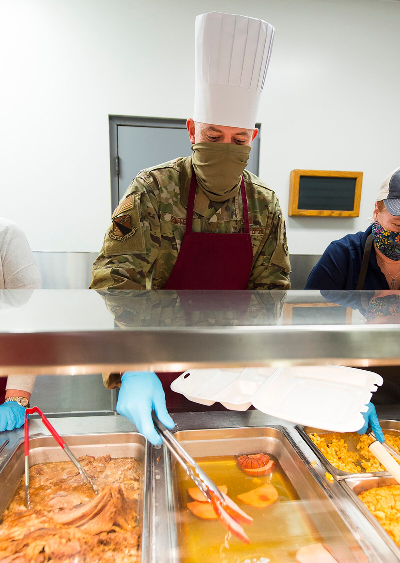 Chief Master Sgt. Jason Shaffer, 88th Air Base Wing command chief, adds a couple of ham slices to a holiday dinner. U.S. AIR FORCE PHOTO/R.J. ORIEZ