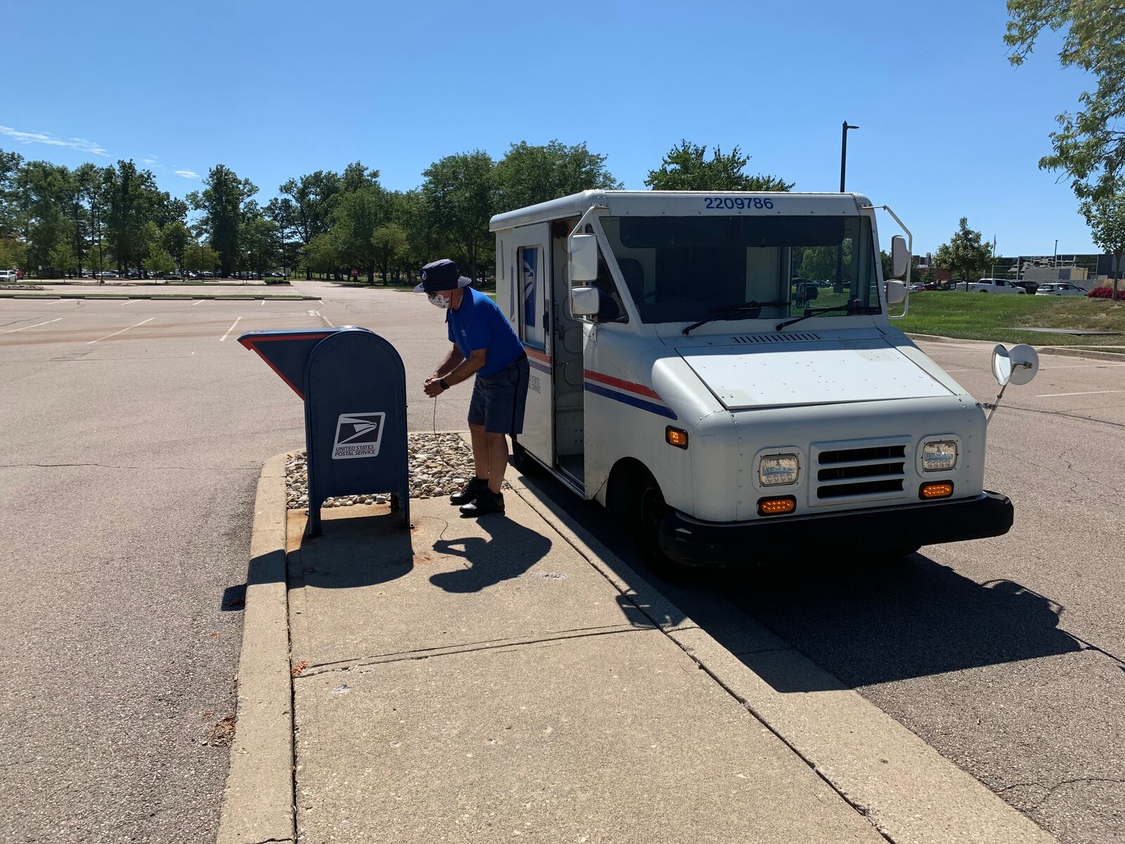 A U.S. Postal Service letter carrier empties a mailbox in Deerfield Twp. in Warren County moments after a reporter dropped in five envelopes as a test of USPS. All five arrived in two days.