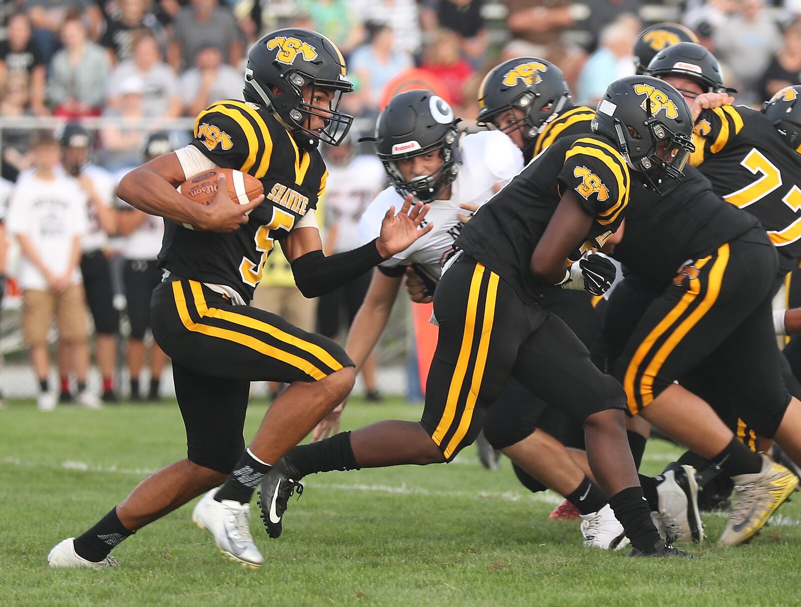 Shawnee’s Robie Glass carries the ball back on a kick off return against Greenon during Friday’s season opener. BILL LACKEY/STAFF