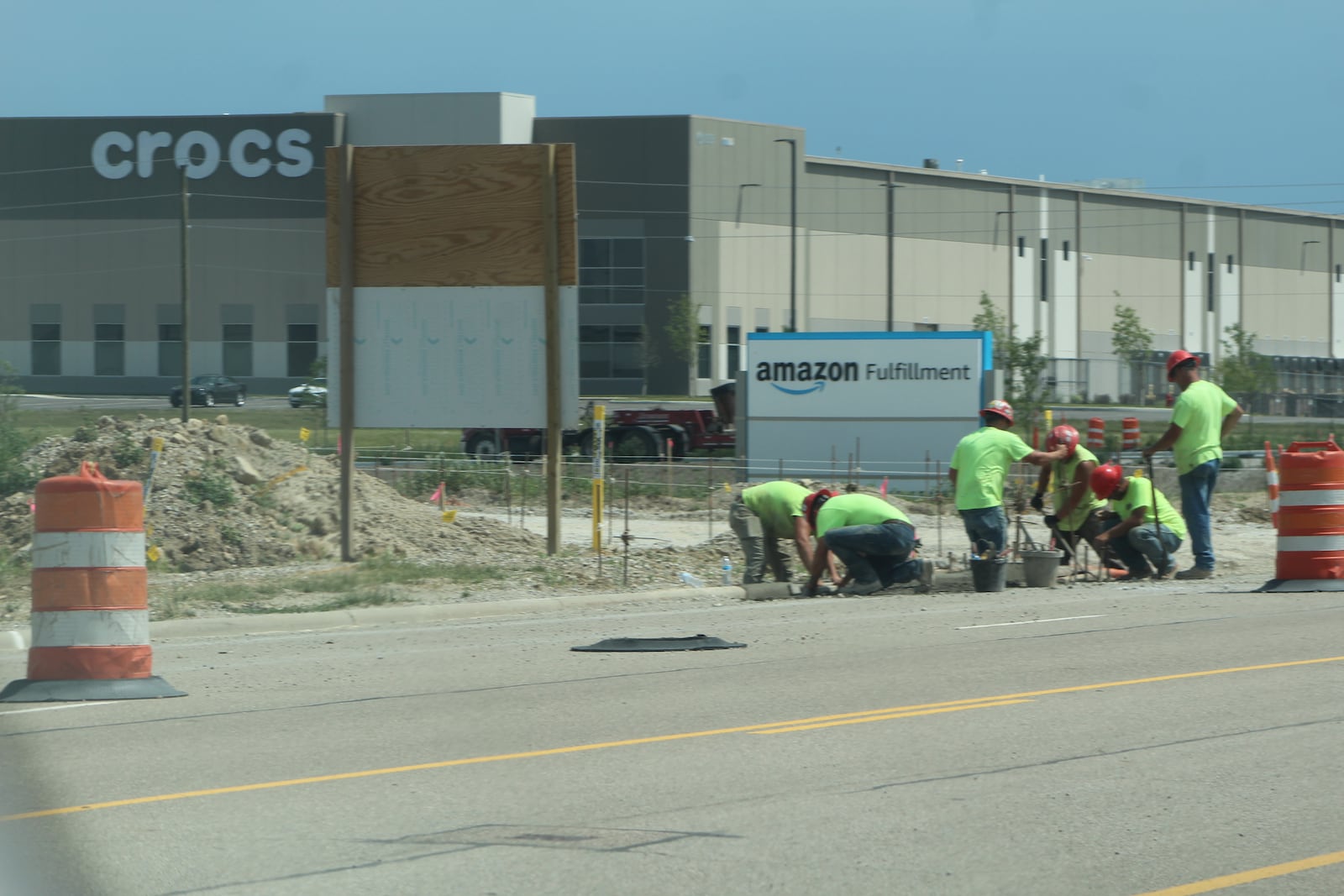 Crews work outside the new Amazon fulfillment center near the Crocs distribution facility and the Dayton International Airport. CORNELIUS FROLIK / STAFF