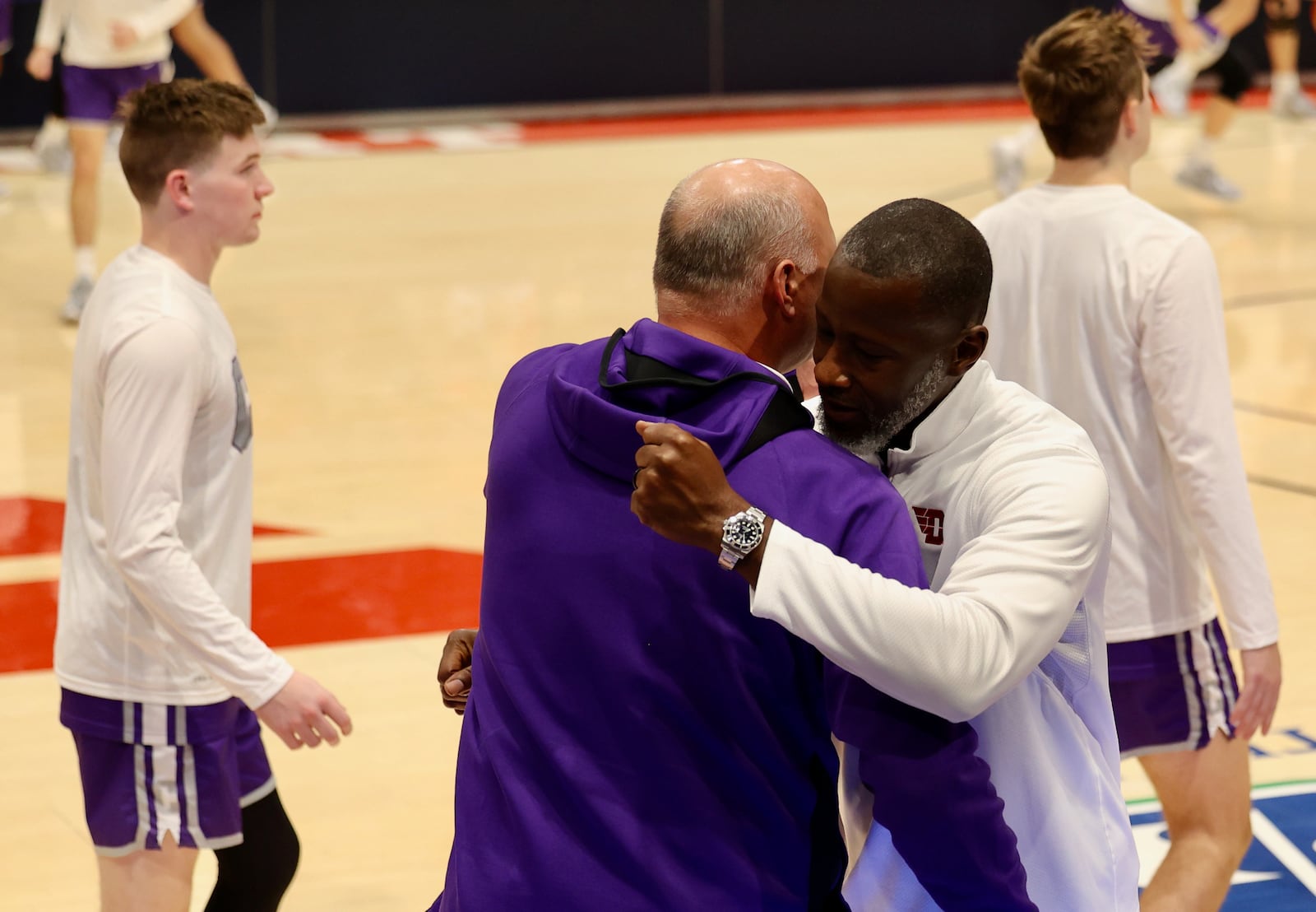 Dayton's Anthony Grant, right, hugs Capital's Damon Goodwin before an exhibition game on Saturday, Oct. 29, 2022, at UD Arena. David Jablonski/Staff