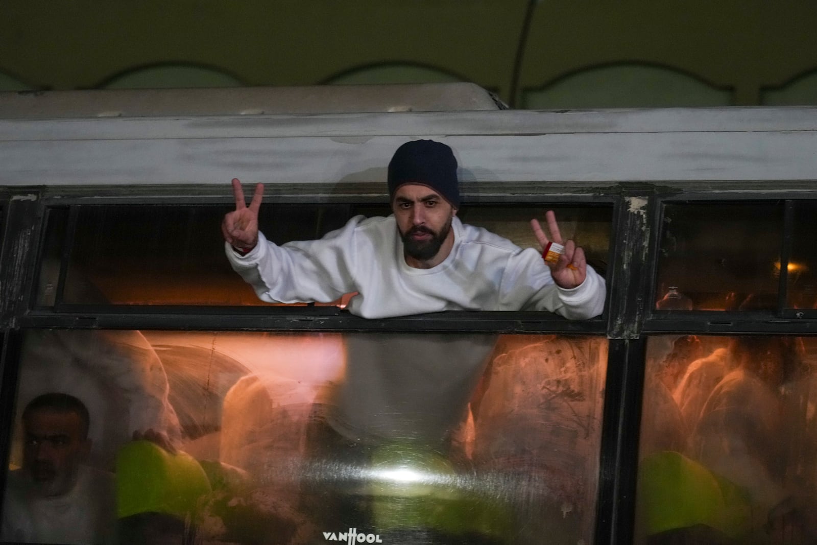 Freed Palestinian prisoners wave from a bus as they arrive in the Gaza Strip after being released from an Israeli prison following a ceasefire agreement between Hamas and Israel in Khan Younis, Gaza Strip, Thursday, Feb. 27, 2025. (AP Photo/Abdel Kareem Hana)