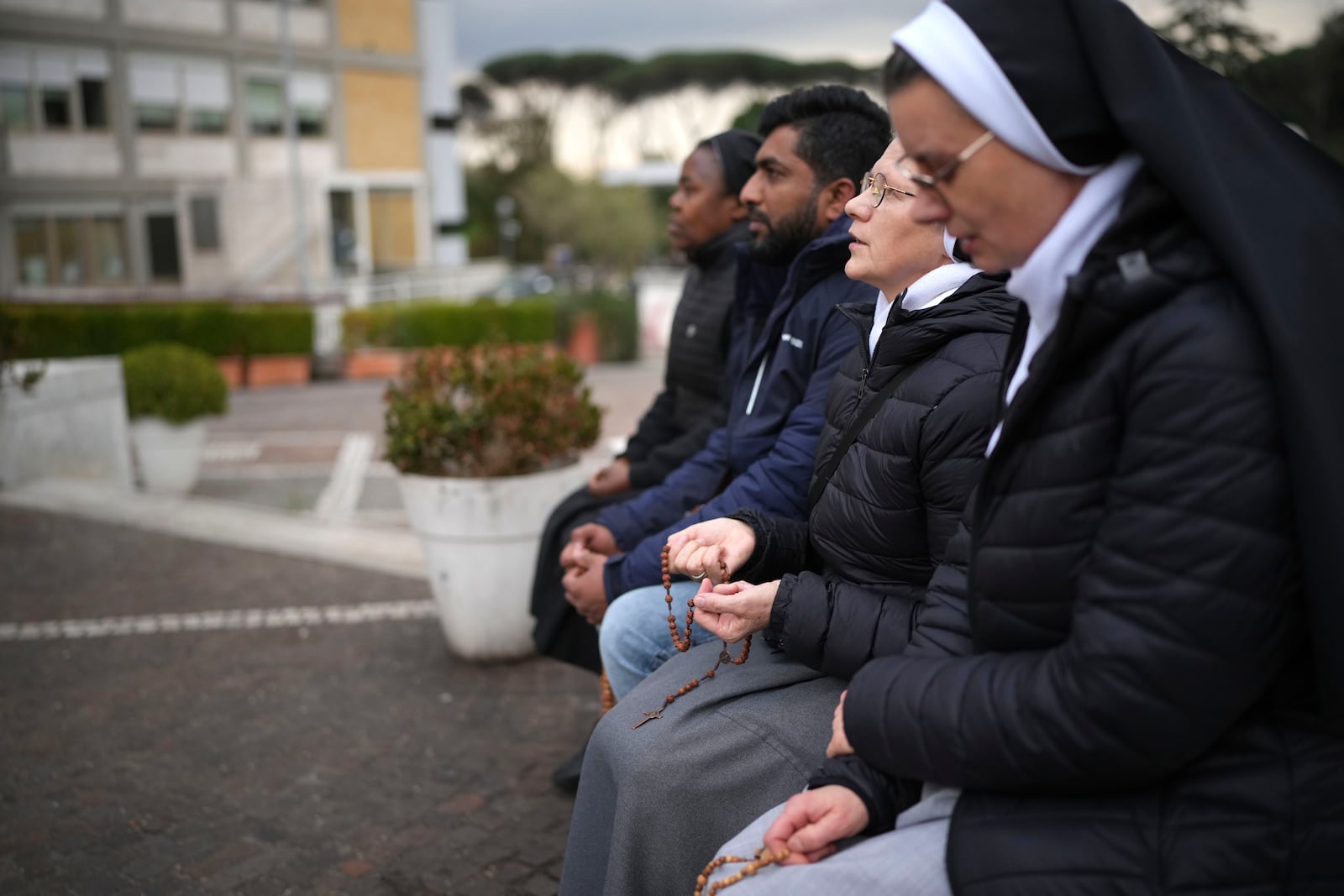 Nuns pray for Pope Francis in front of the statue of Pope John Paul II at the Agostino Gemelli Polyclinic, in Rome, Thursday, Feb. 20, 2025, where the Pontiff is hospitalized since Friday, Feb. 14. (AP Photo/Alessandra Tarantino)