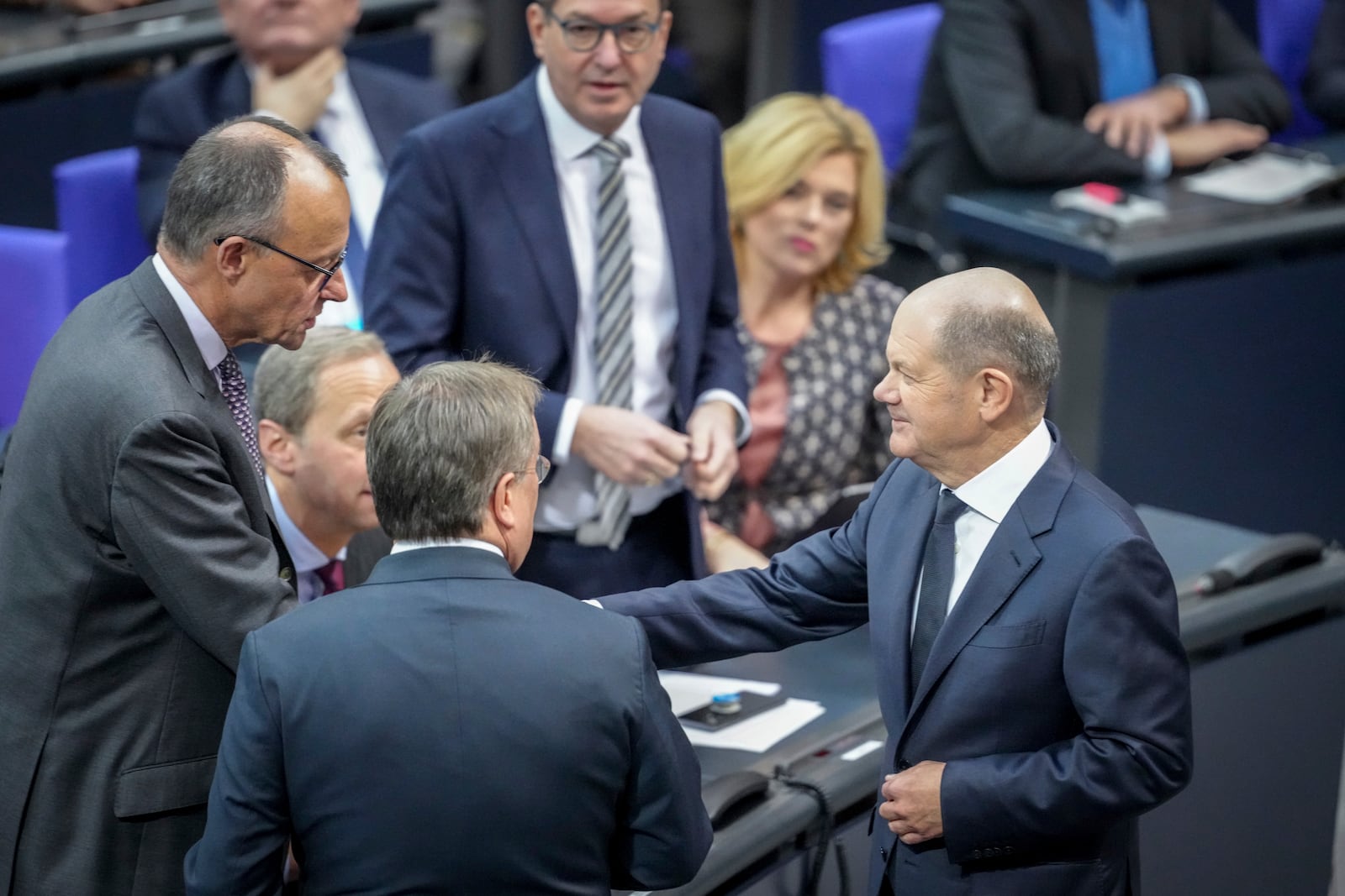 German Chancellor Olaf Scholz, right, and the faction leader of the German Christian Democratic party (CDU), Friedrich Merz, right, shake hands before a questioning during a meeting of the German federal parliament, Bundestag, at the Reichstag building in Berlin, Germany, Wednesday, Dec. 4, 2024. (Kay Nietfeld/dpa via AP)