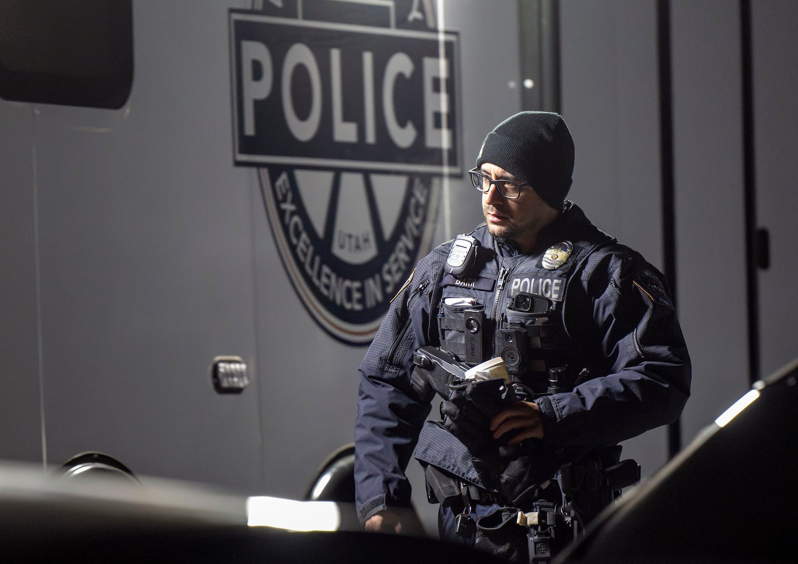 An officer walks past a command trailer as police investigate a crime scene where they say multiple family members were found dead inside a home in West Valley City, Utah, Tuesday Dec. 17, 2024. (Scott G. Winterton/The Deseret News via AP)