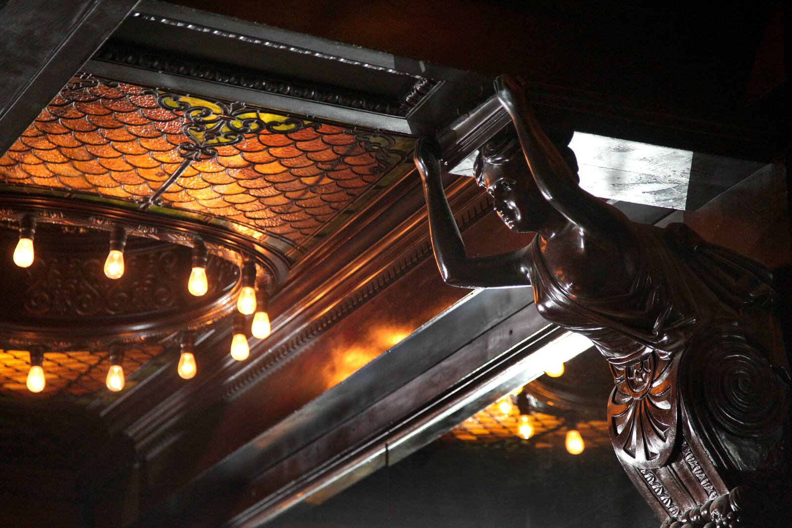 Carved maidens and stained glass are highlights of the historic back bar at downtown Dayton's Century Bar. LISA POWELL / STAFF