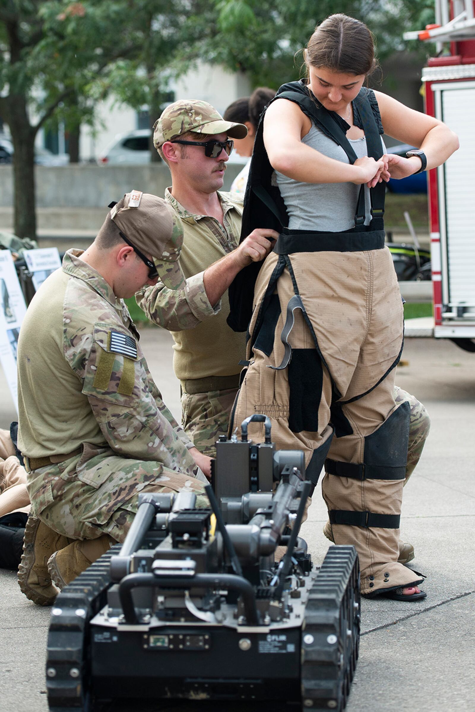 Members of the 788th Civil Engineer Squadron’s Explosive Ordnance Disposal Flight help a Dayton Dragons fan try on a bomb suit Aug. 21 at their hands-on exhibit outside Day Air Credit Union Ballpark. U.S. AIR FORCE PHOTO/WESLEY FARNSWORTH