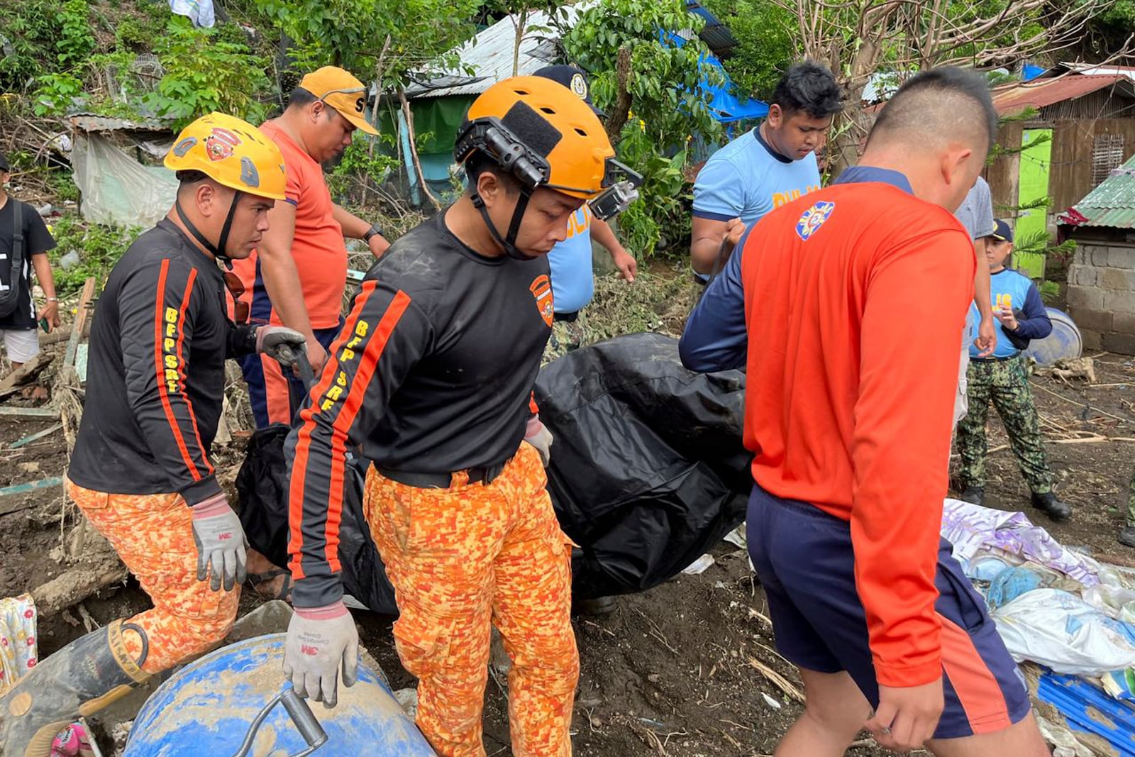 Rescuers carry a body after a landslide triggered by Tropical Storm Trami struck homes in Talisay, Batangas province, Philippines, Saturday, Oct. 26, 2024. (AP Photo/Jim Gomez)