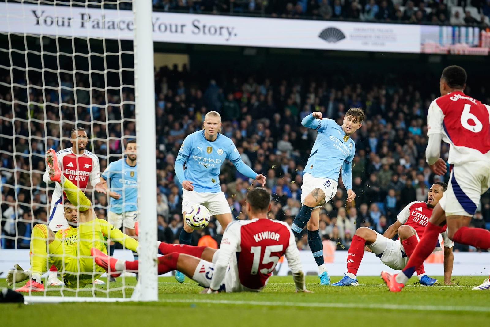 Manchester City's John Stones, center, scores his side's second goal during the English Premier League soccer match between Manchester City and Arsenal at the Etihad stadium in Manchester, England, Sunday, Sept. 22, 2024. (AP Photo/Dave Thompson)